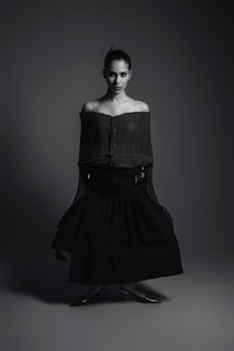 A black and white photo of a woman in a dress