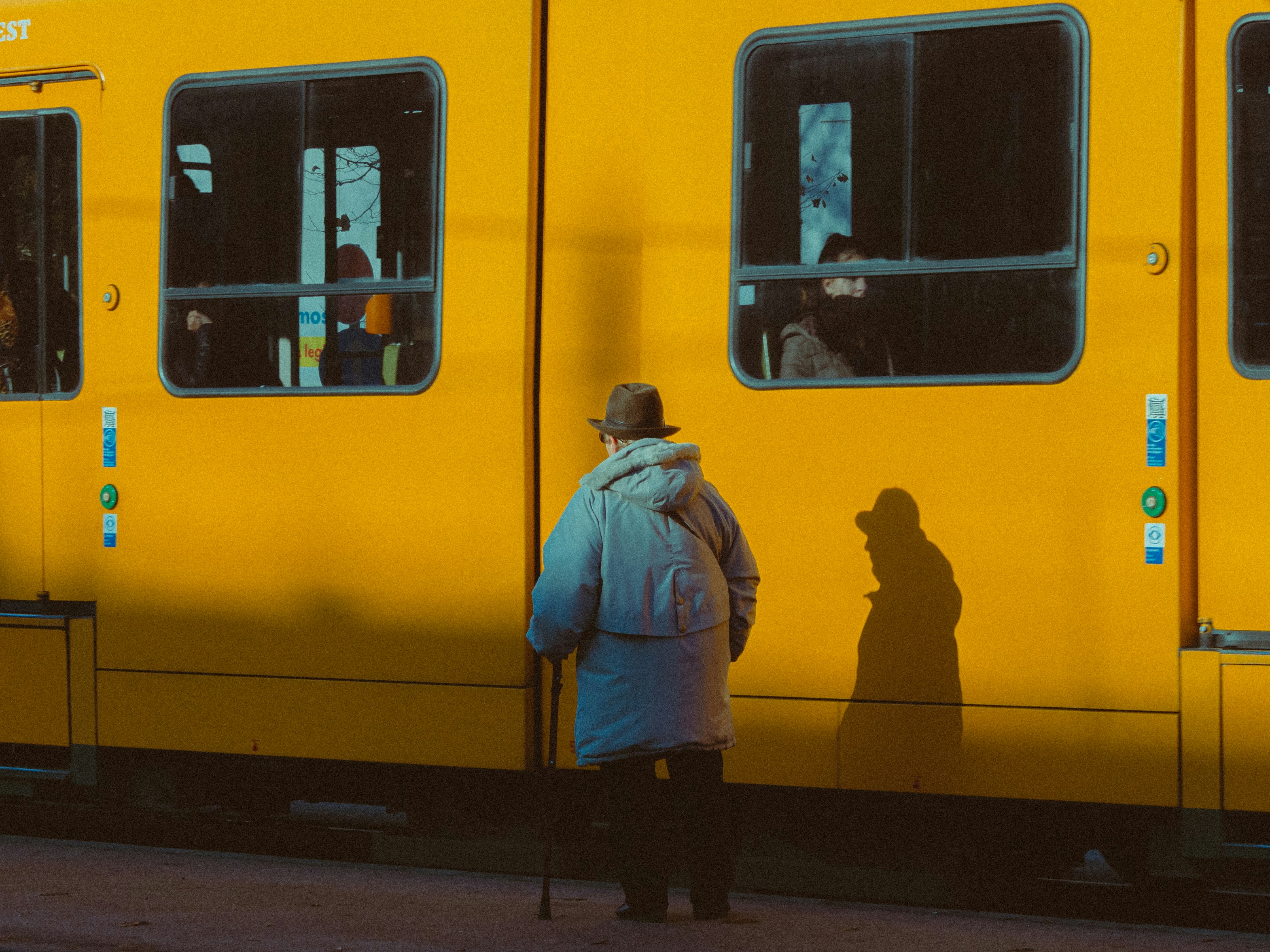 A person standing in front of a yellow train