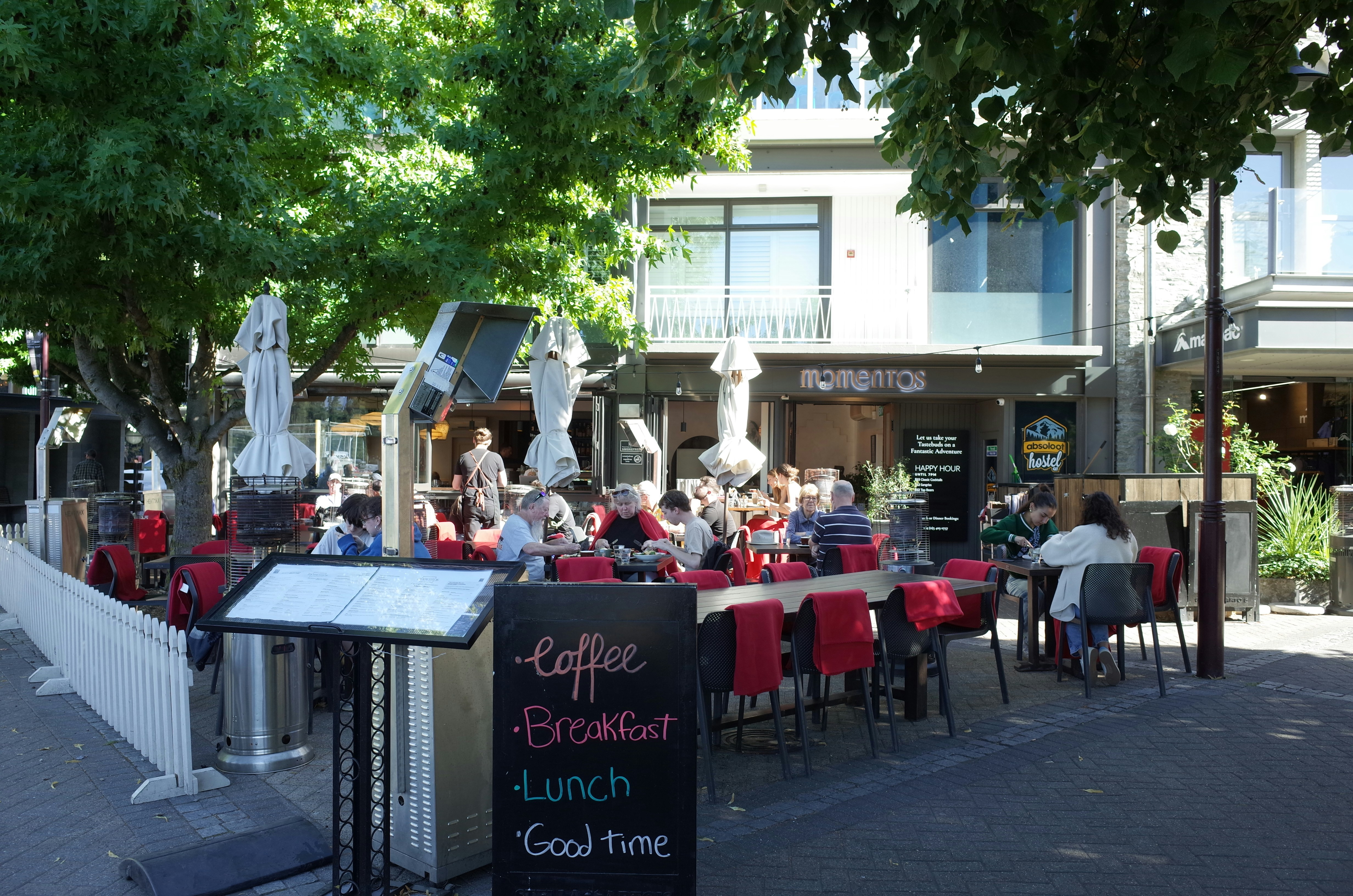 A group of people sitting at tables in front of a building