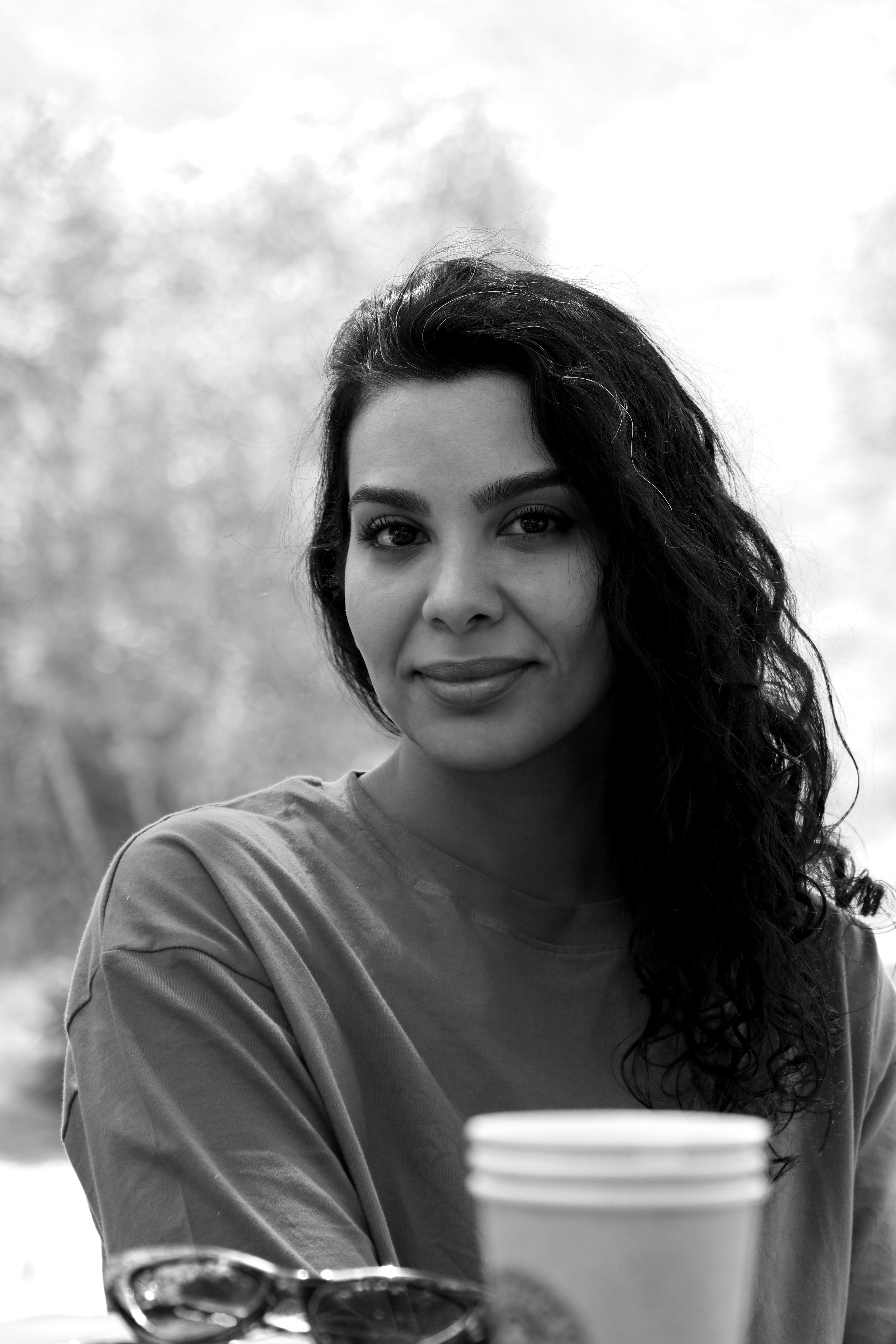 A woman sitting at a table with a cup of coffee