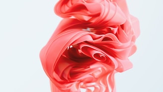 A pink vase with a flower on top of it