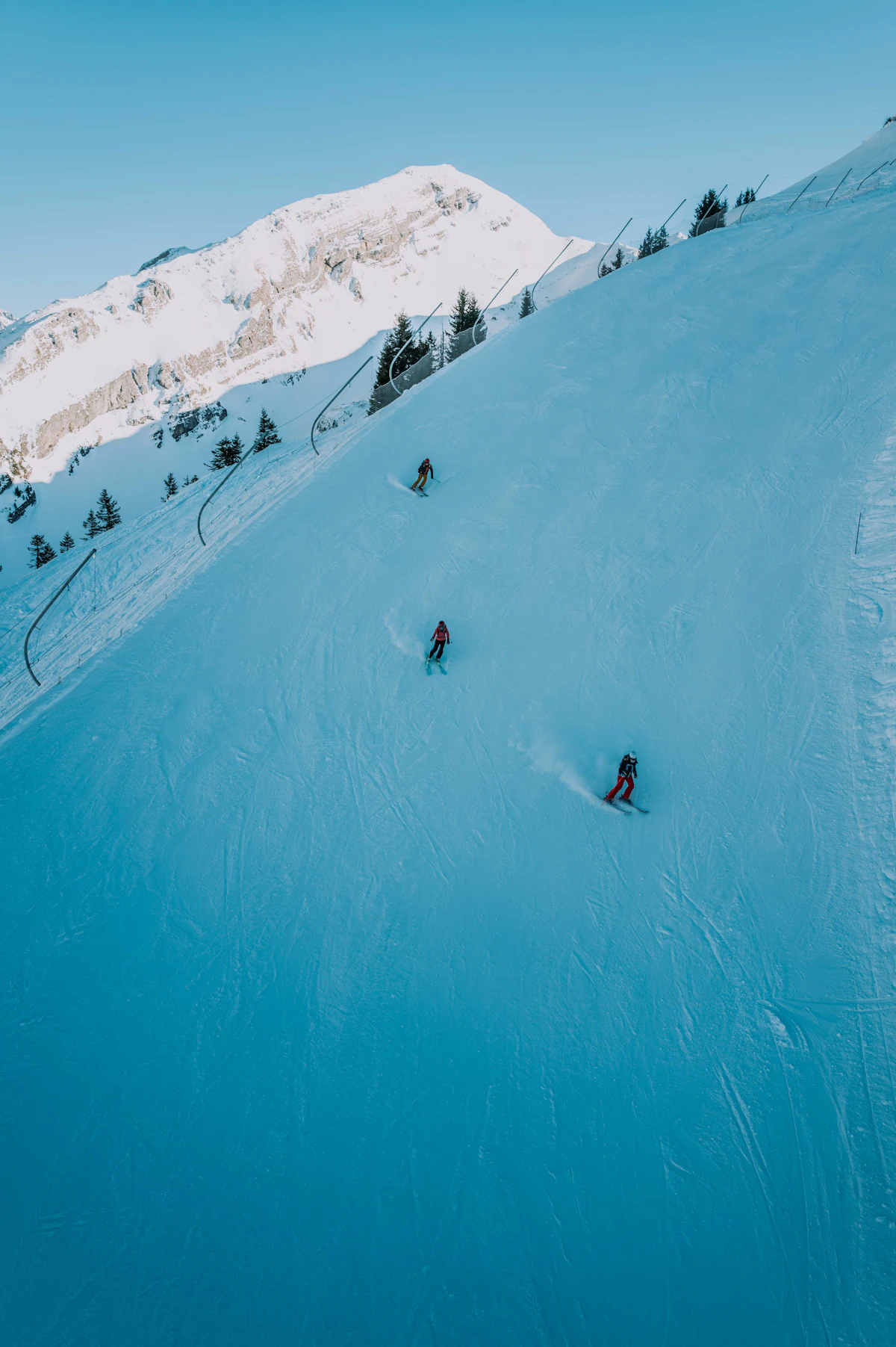 A group of skiers heading down a snow-covered mountain slope