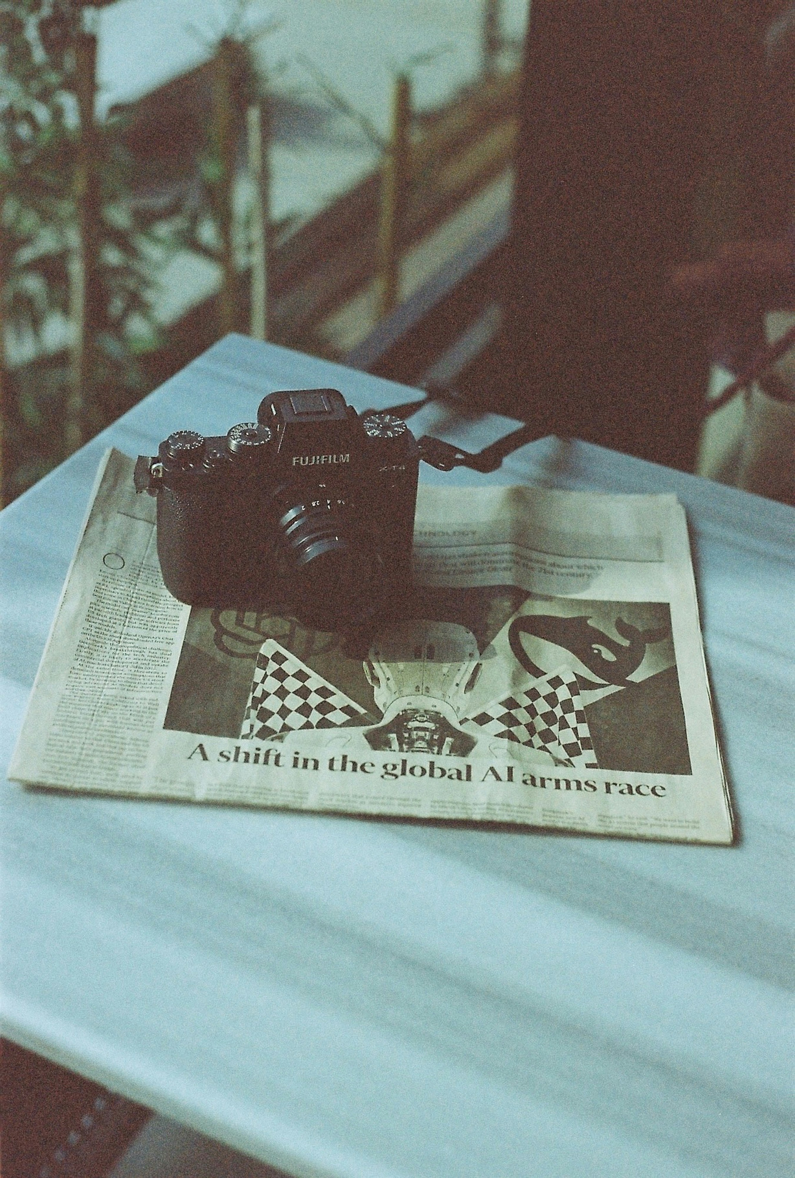 A camera sitting on top of a newspaper on a table