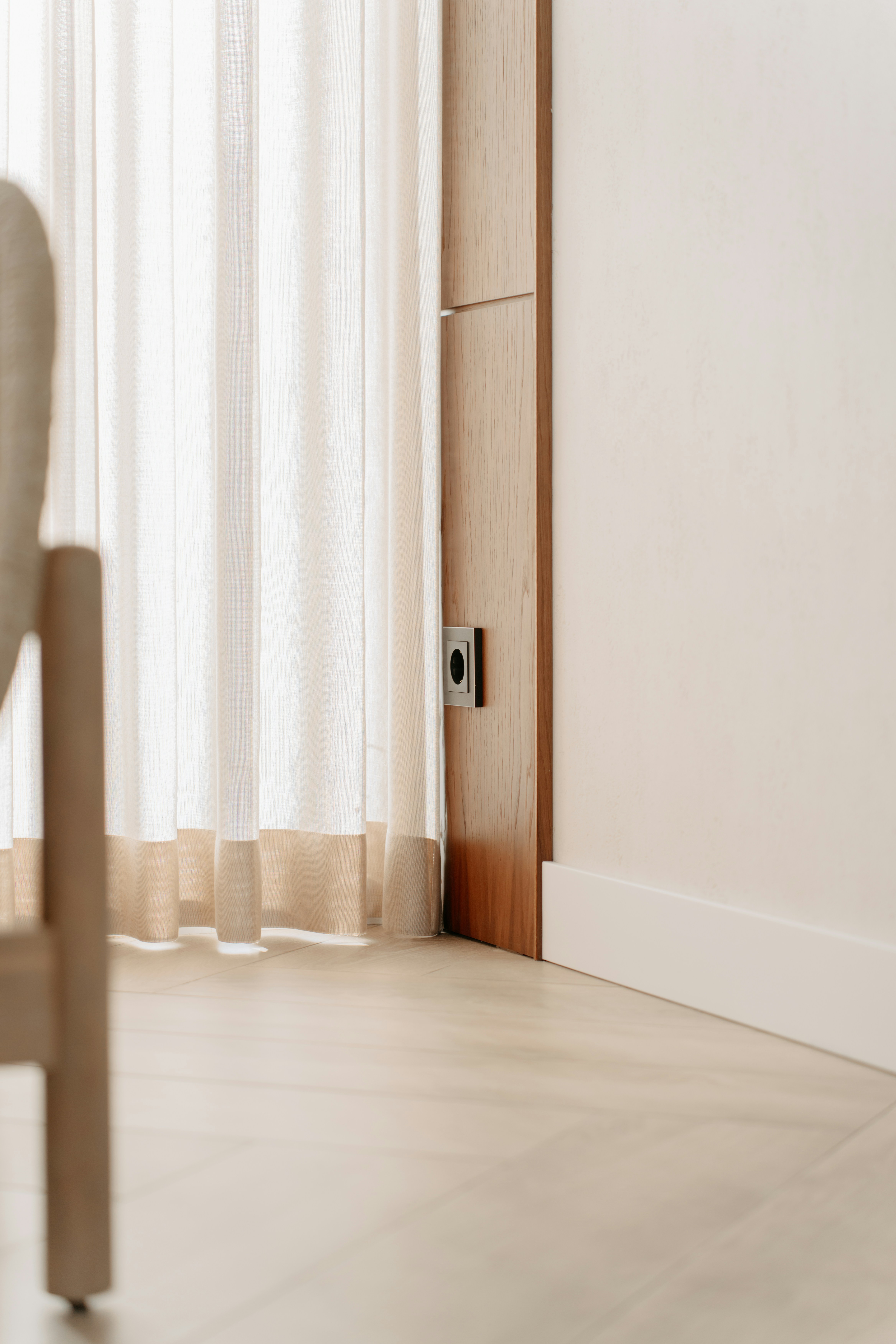 Una sedia bianca seduta in una stanza accanto a una porta
