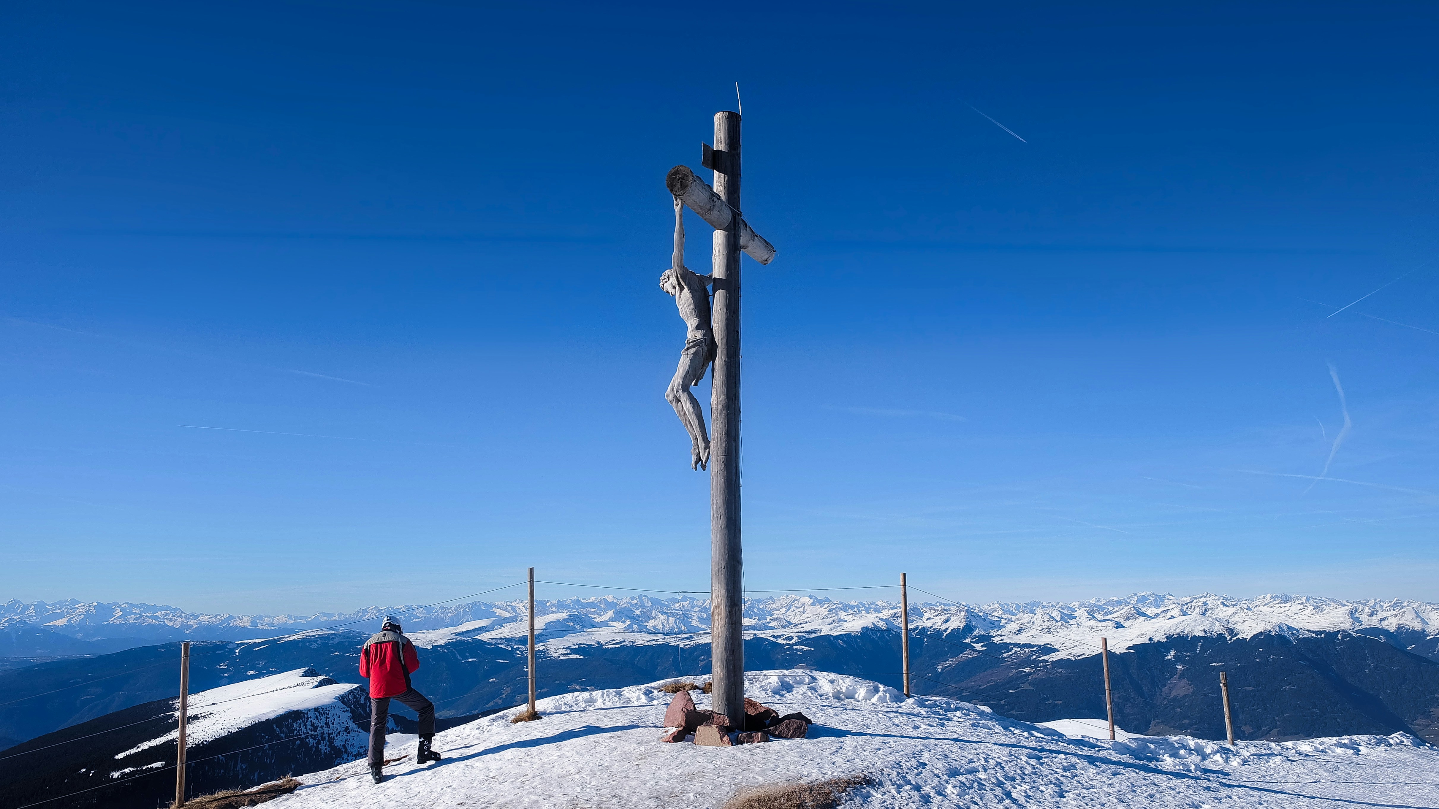 A person standing on top of a snow covered mountain