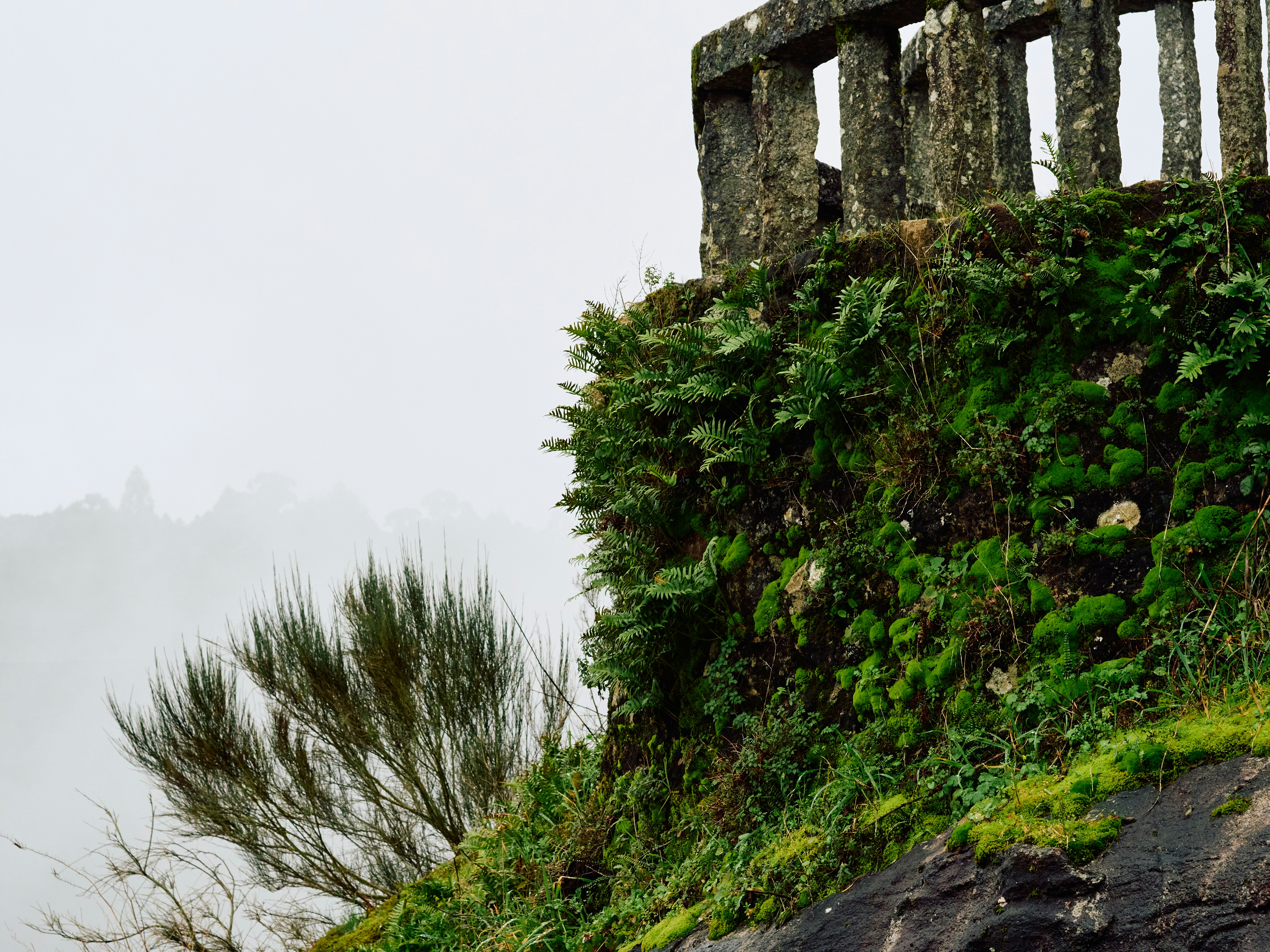 A stone fence on top of a grassy hill