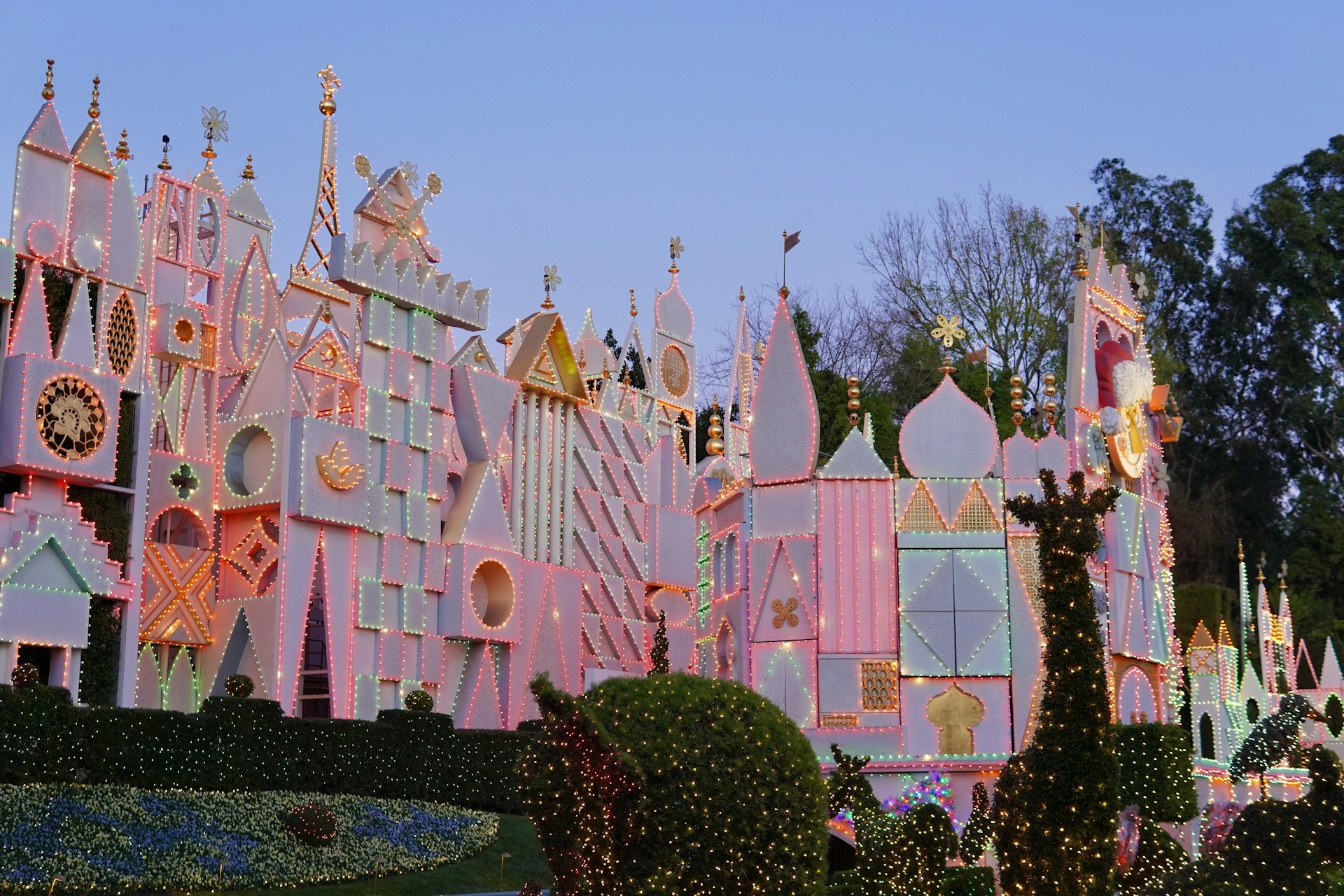A large pink castle with lots of lights on it