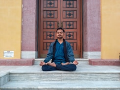 A man sitting on a step in front of a door