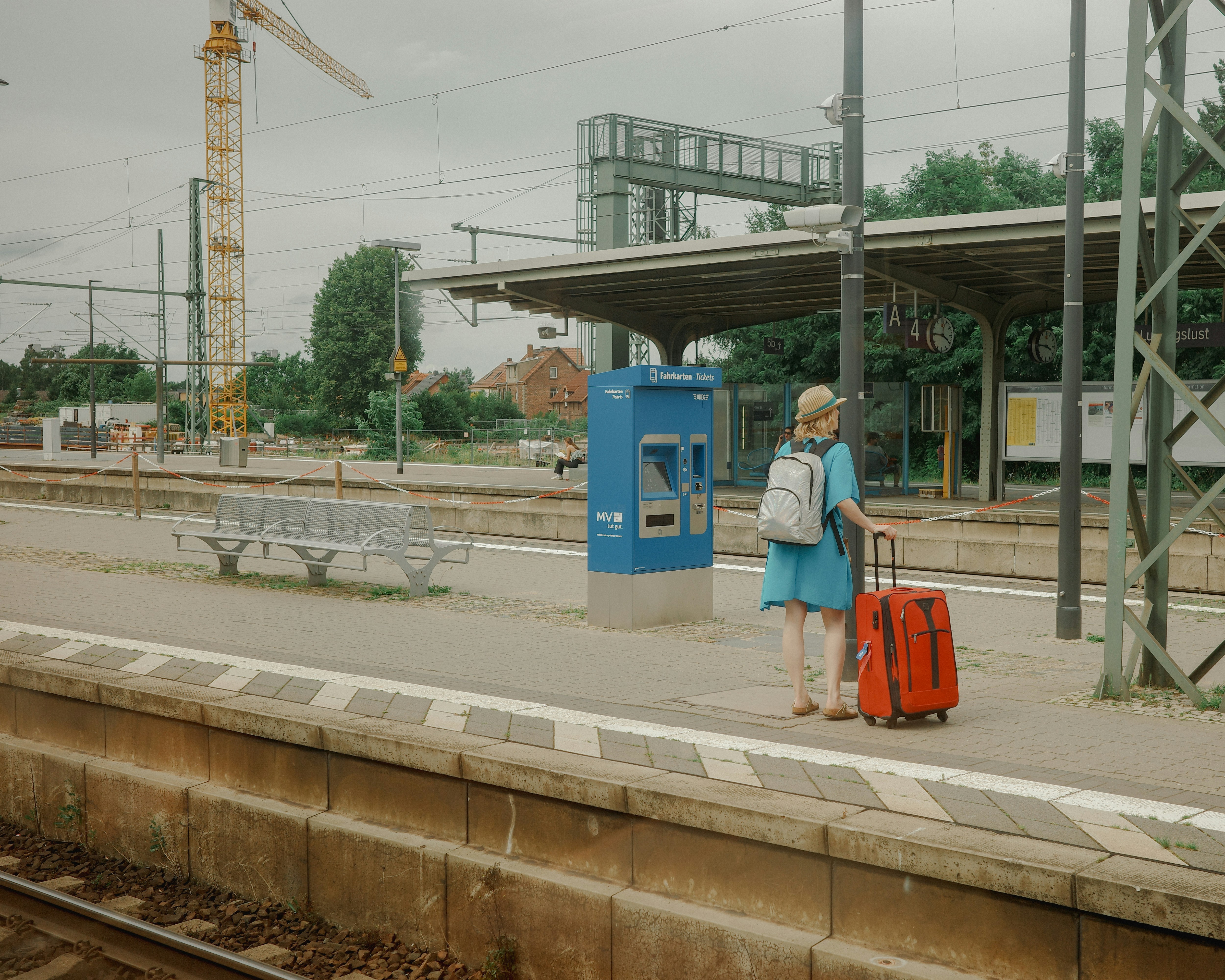 A woman with a suitcase waiting at a train station