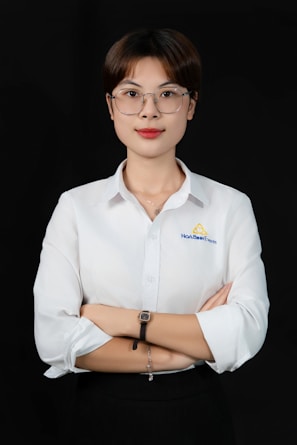 A woman wearing glasses and a white shirt