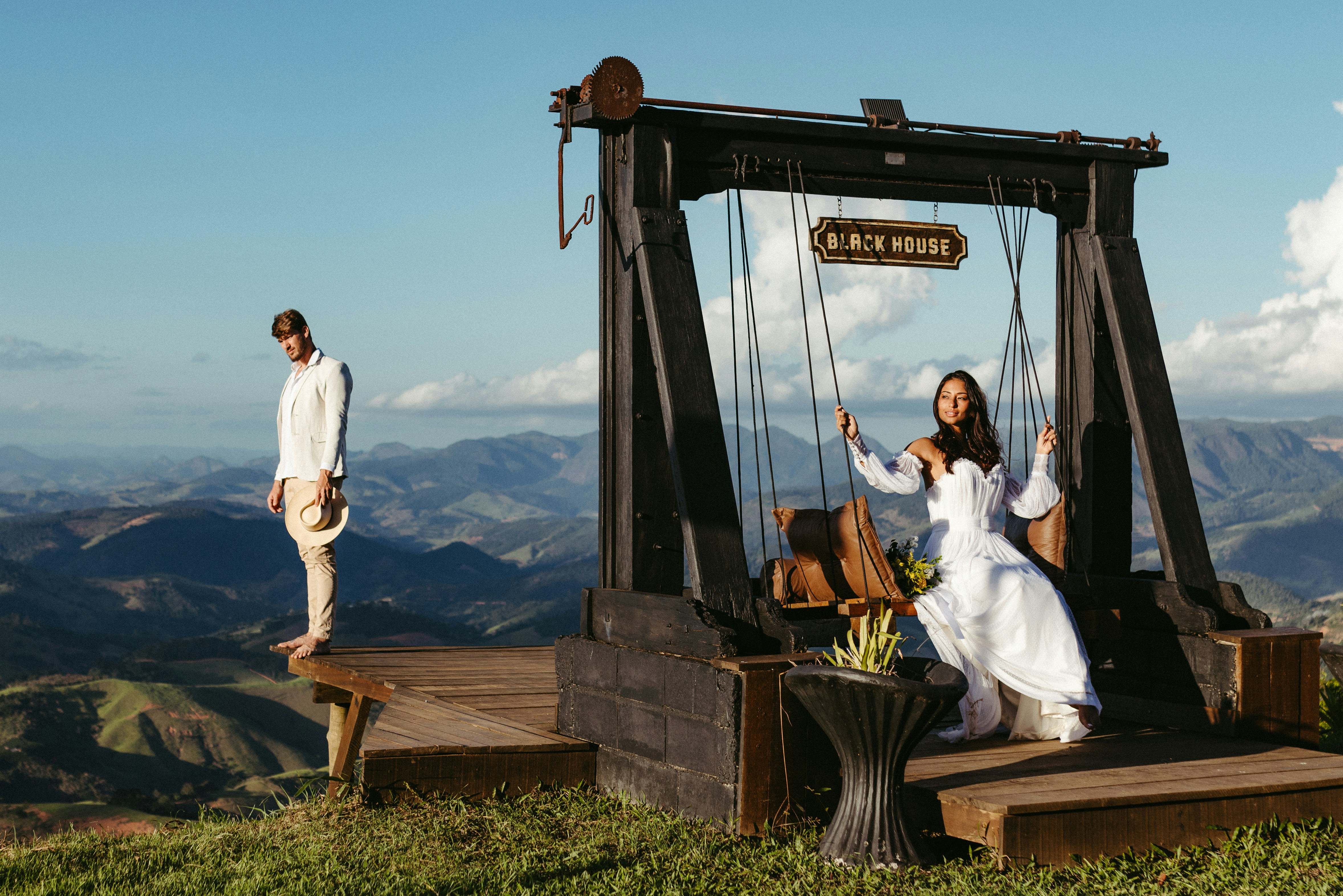 A man and woman standing on top of a wooden structure