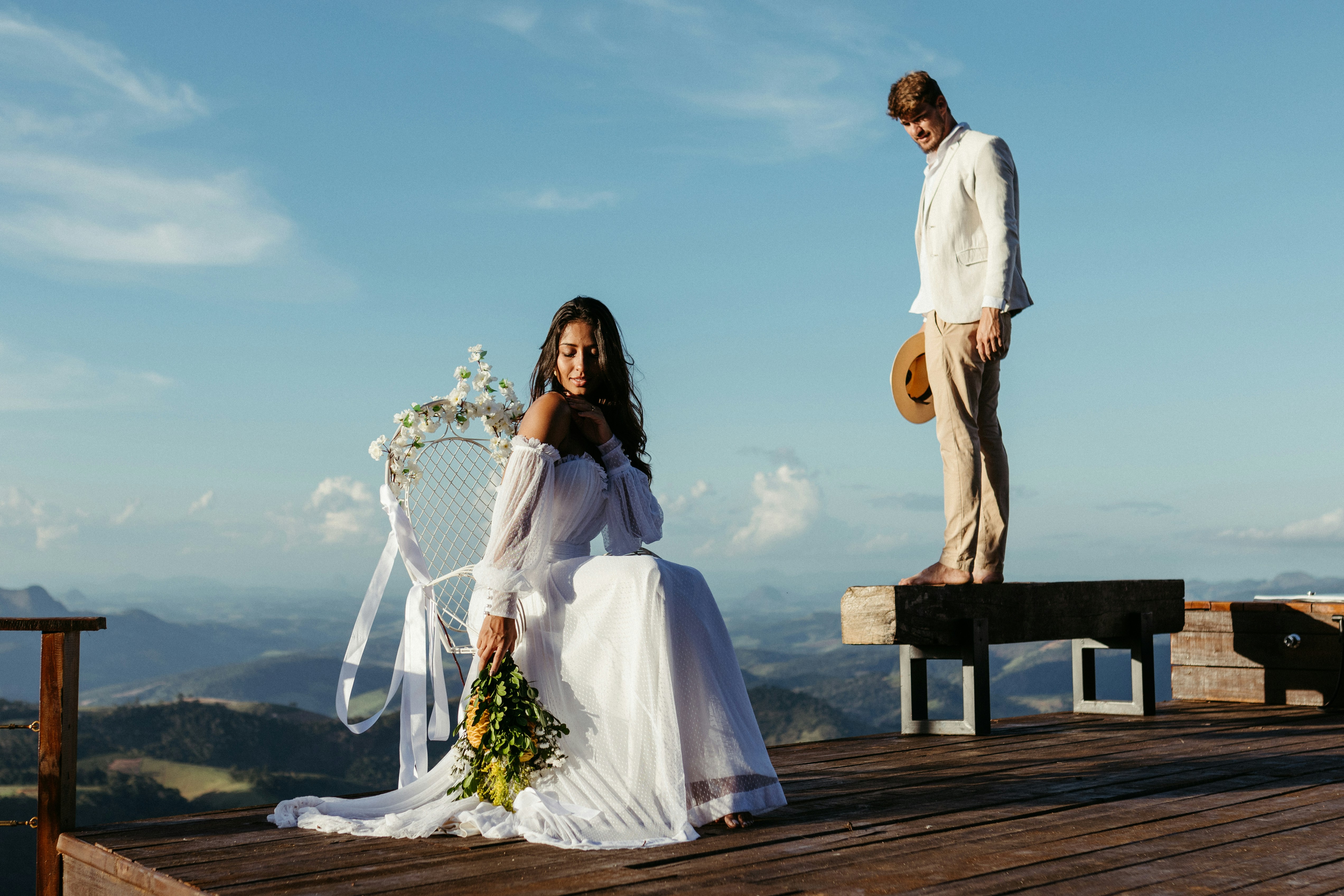 A bride and groom standing on a wooden platform