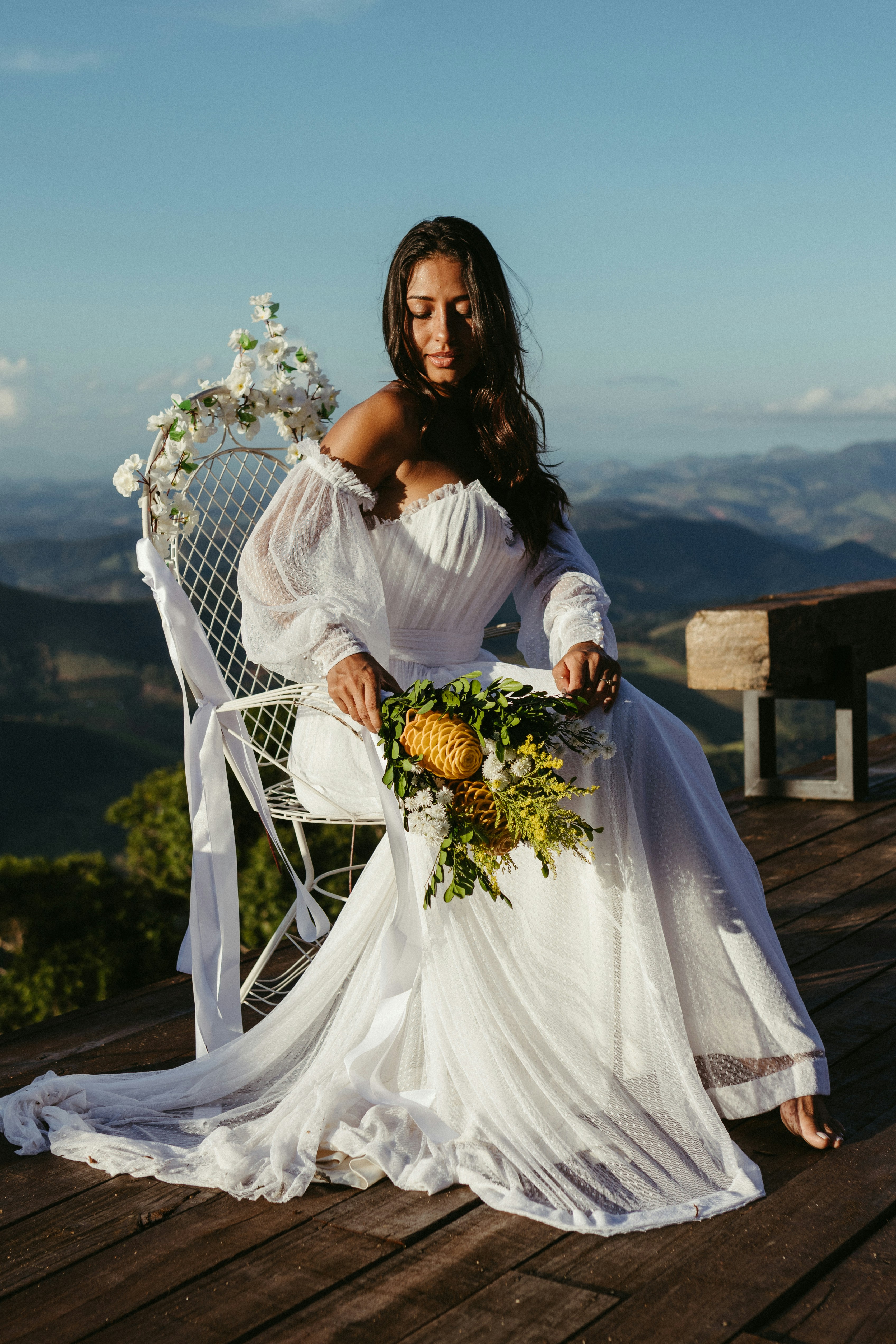 A woman in a white dress sitting on a white chair