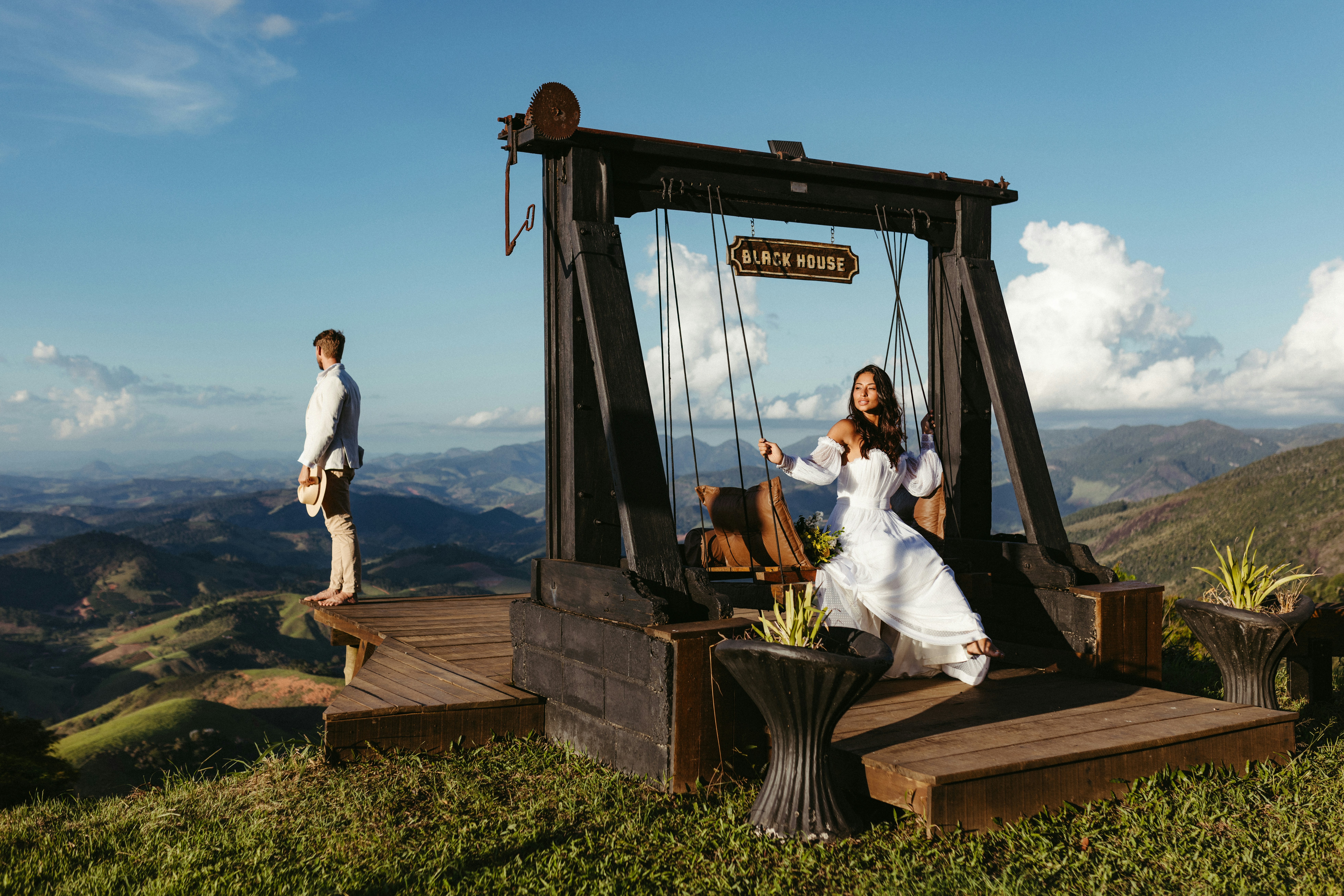 A man and a woman standing on top of a hill