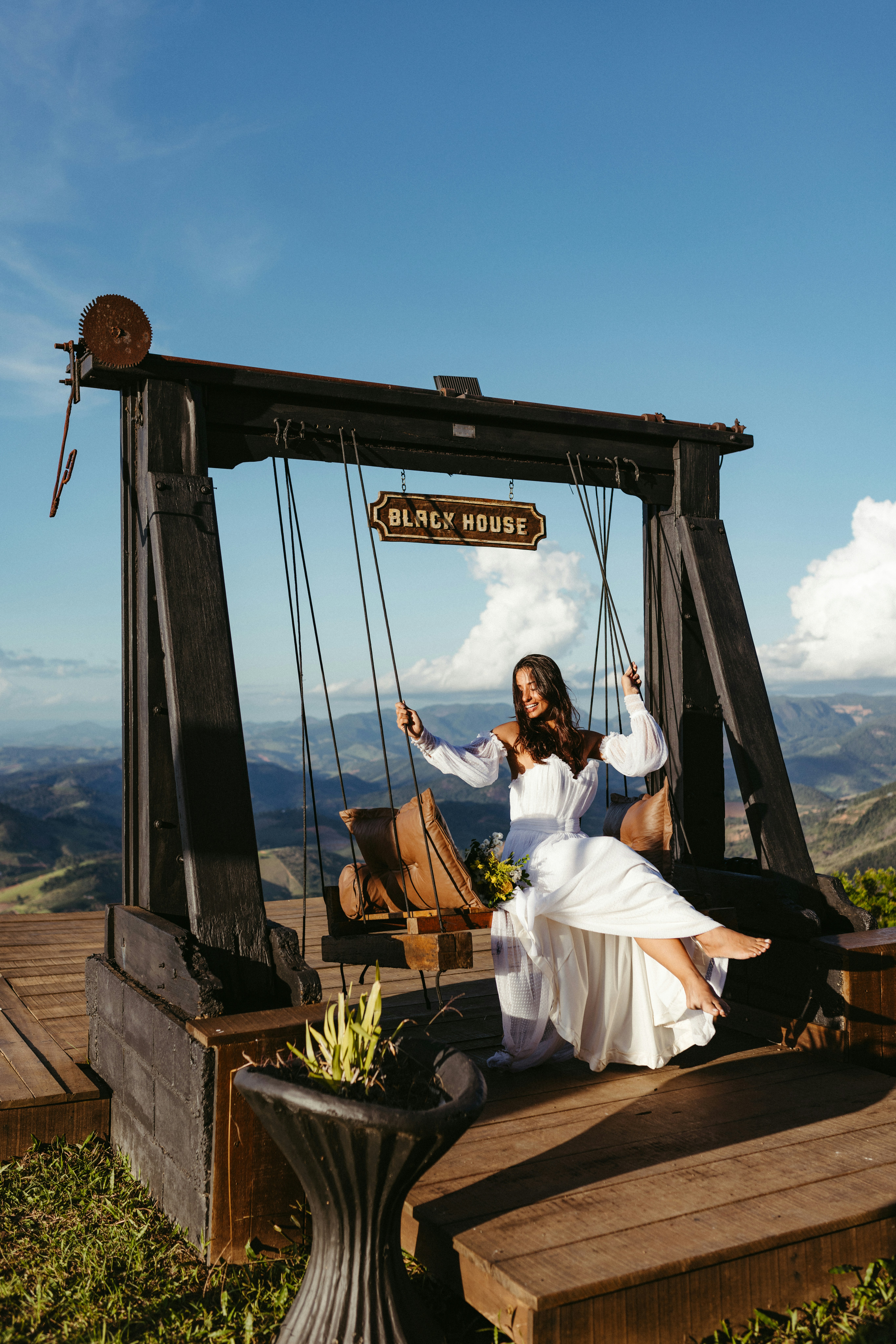 A woman in a white dress sitting on a swing