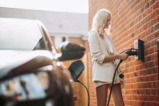 A woman is charging her car at a gas station