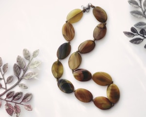 Two necklaces of different shapes and colors on a white surface