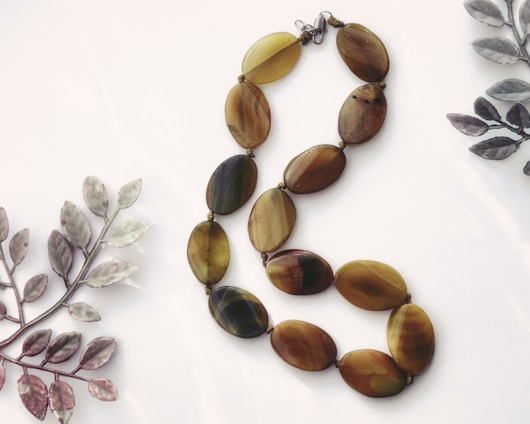 Two necklaces of different shapes and colors on a white surface