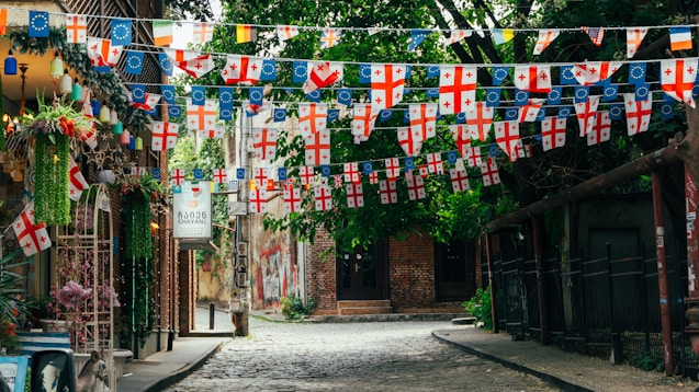 A narrow street with a lot of flags hanging from it's sides