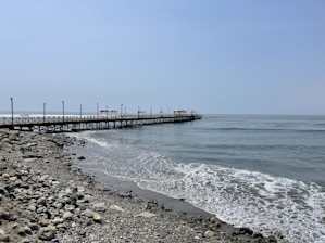 A pier on a rocky beach next to the ocean