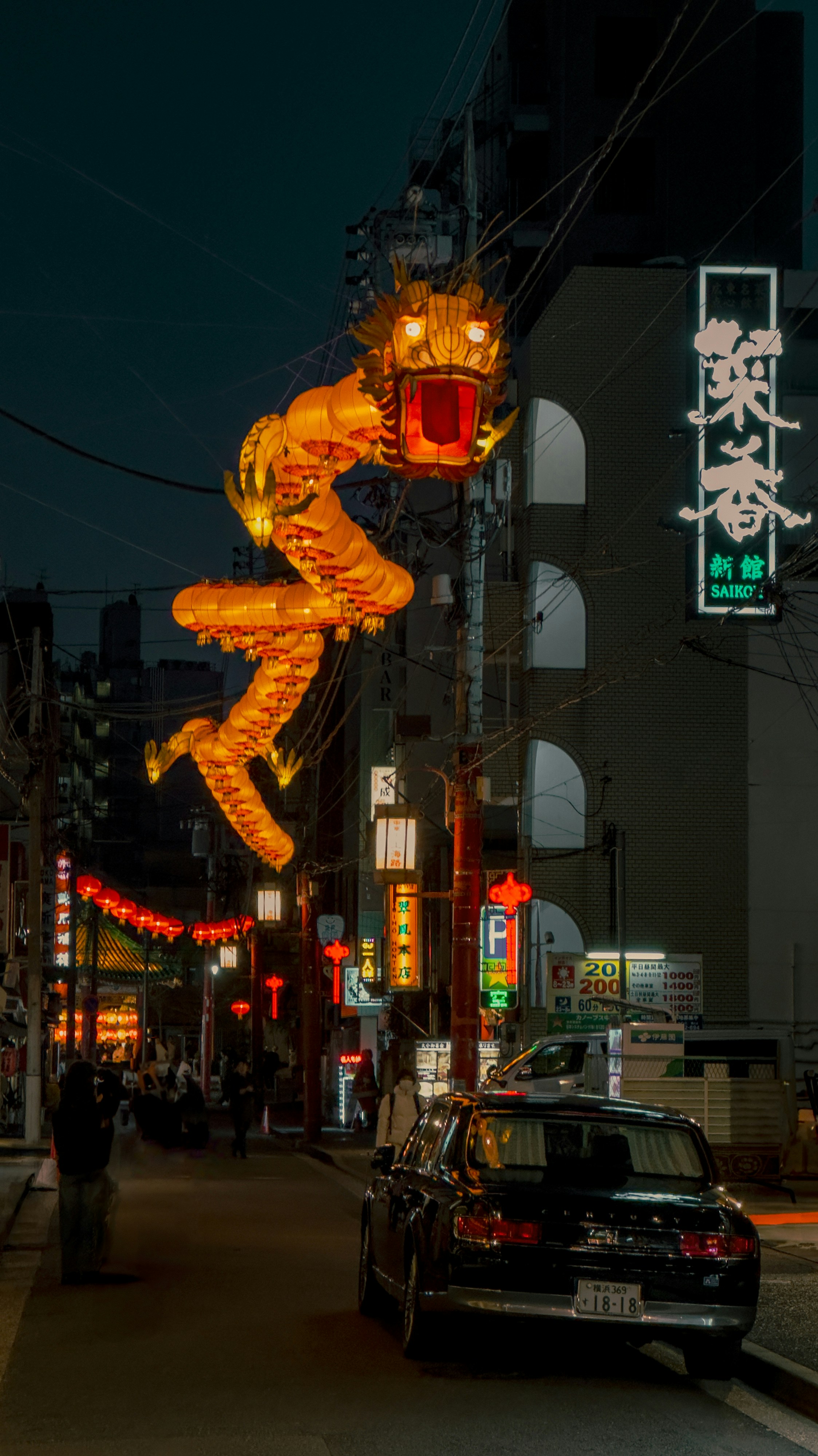A car driving down a street next to a tall building