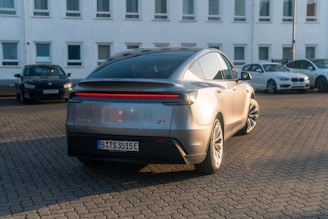 A silver car parked in front of a white building