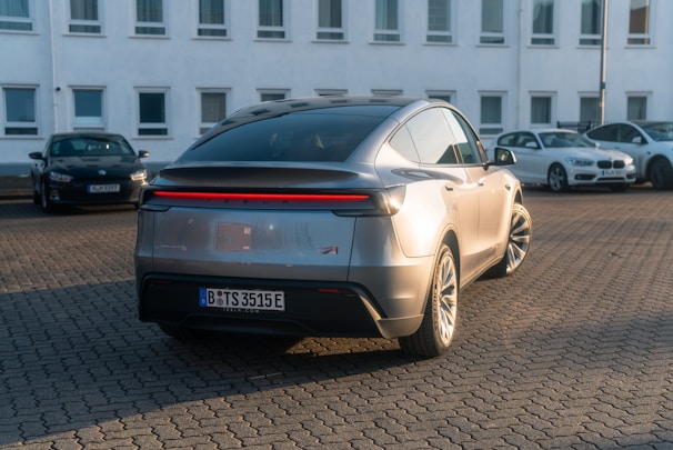 A silver car parked in front of a white building