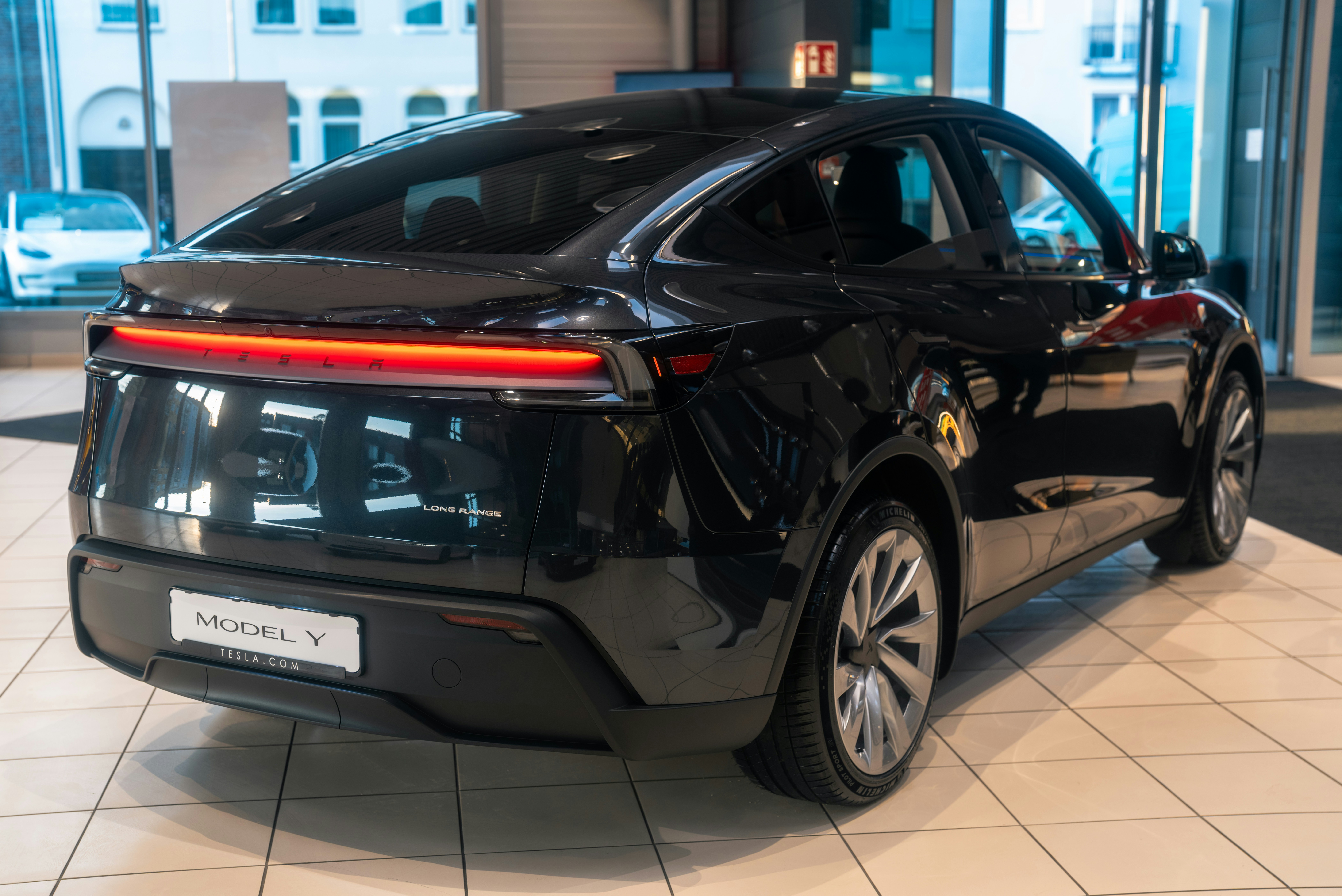 A black car is parked in a showroom