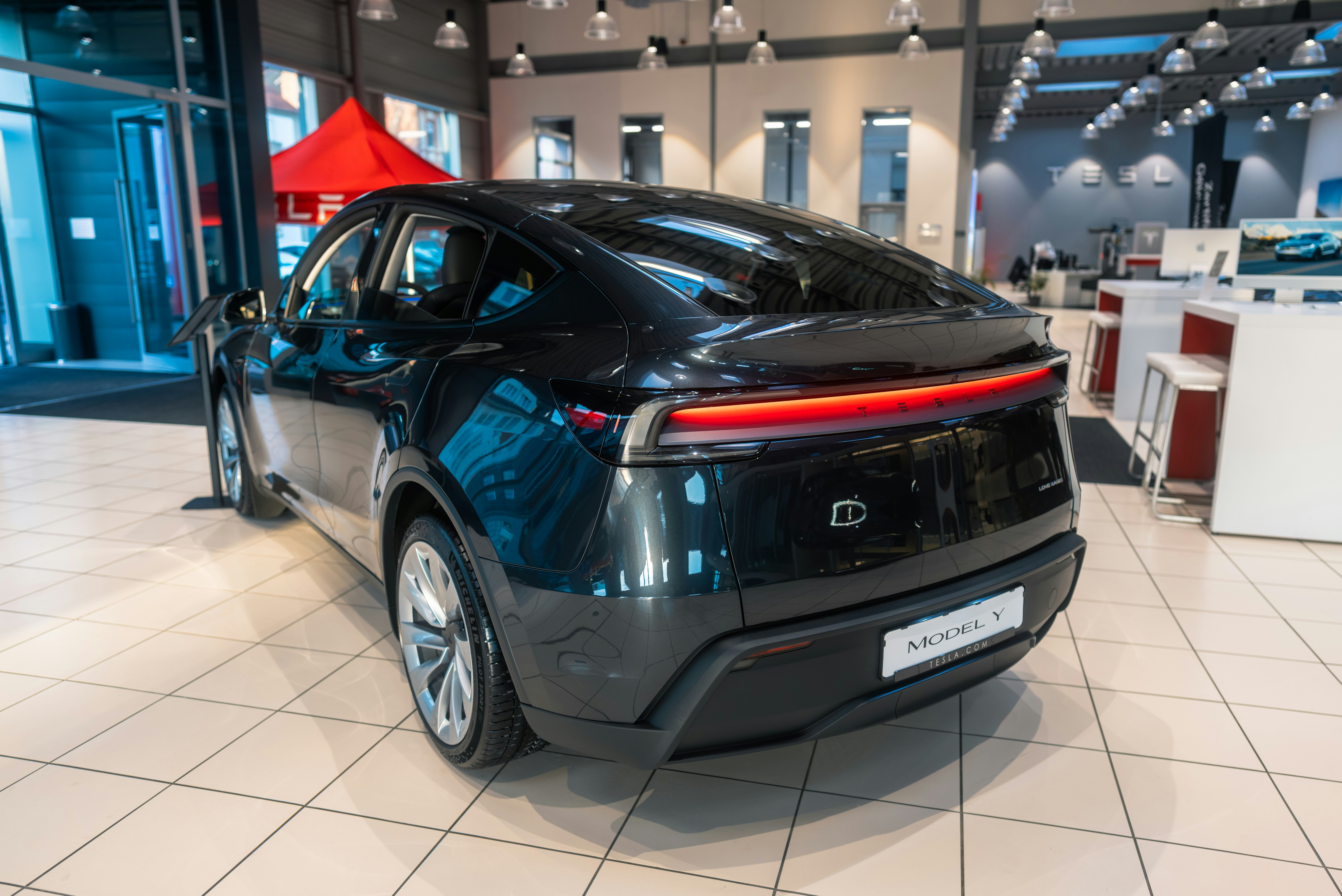 Young couple looking at used cars on a dealership lot while discussing options
