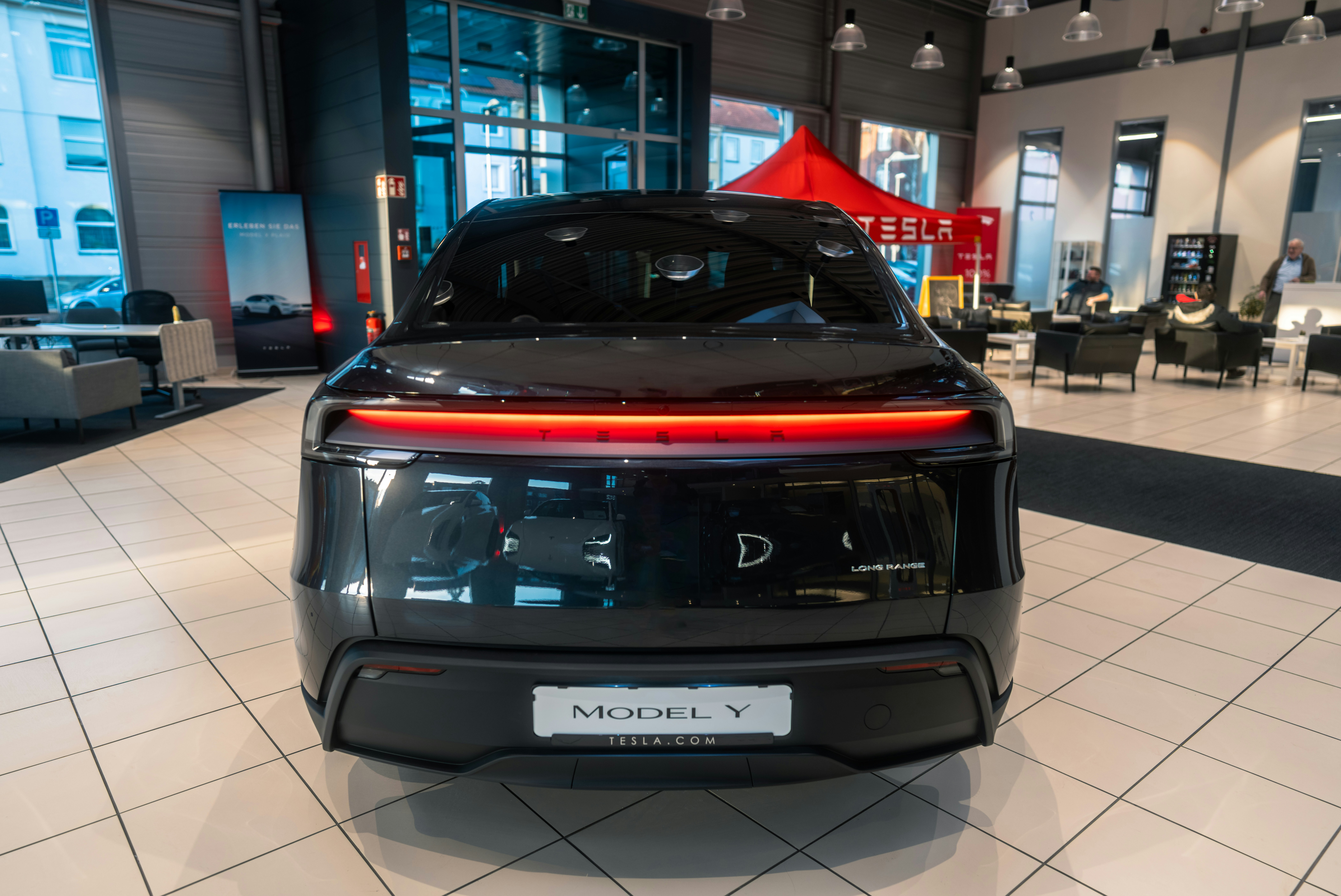 A black sports car is parked in a showroom