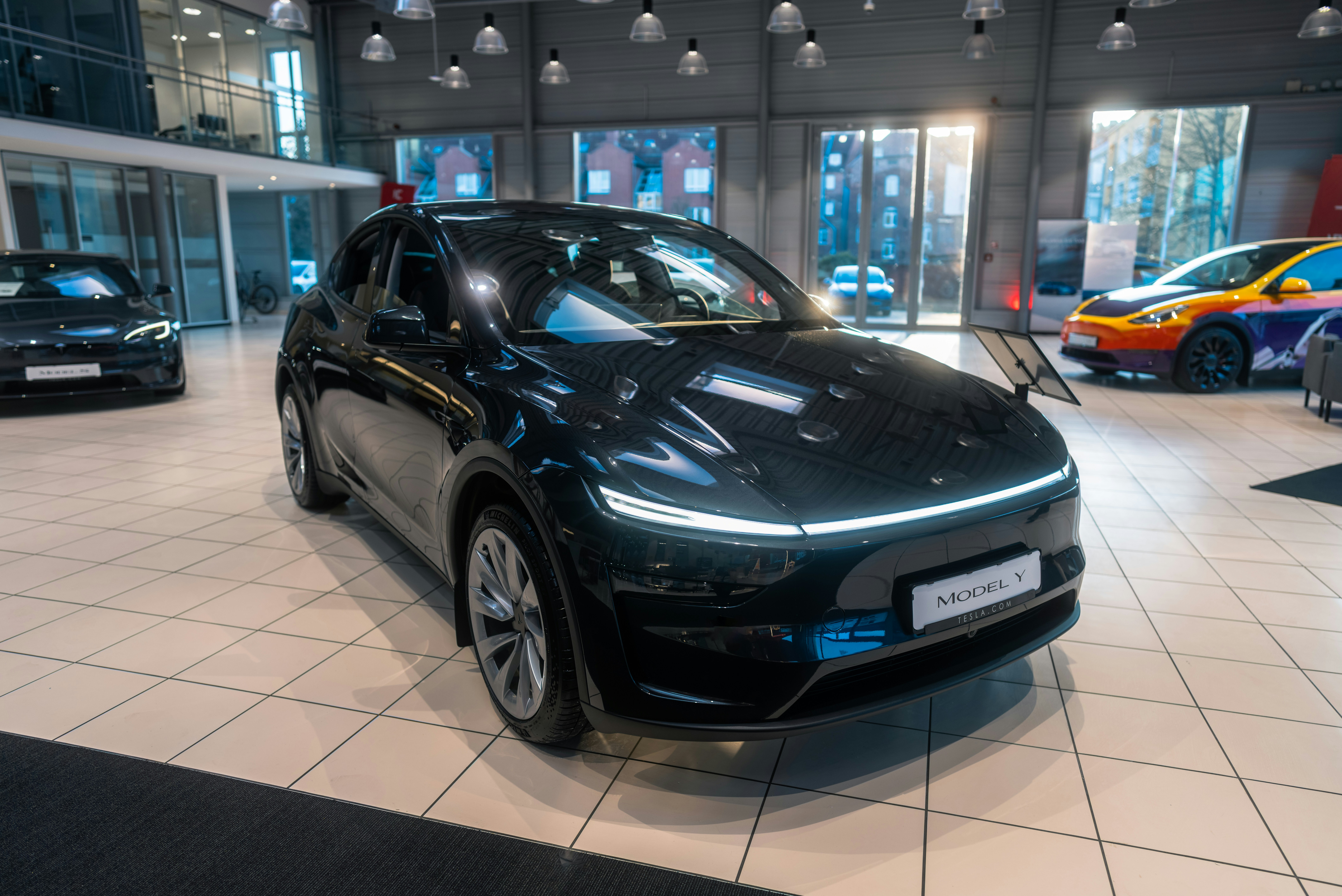 A car is parked in a showroom with other cars