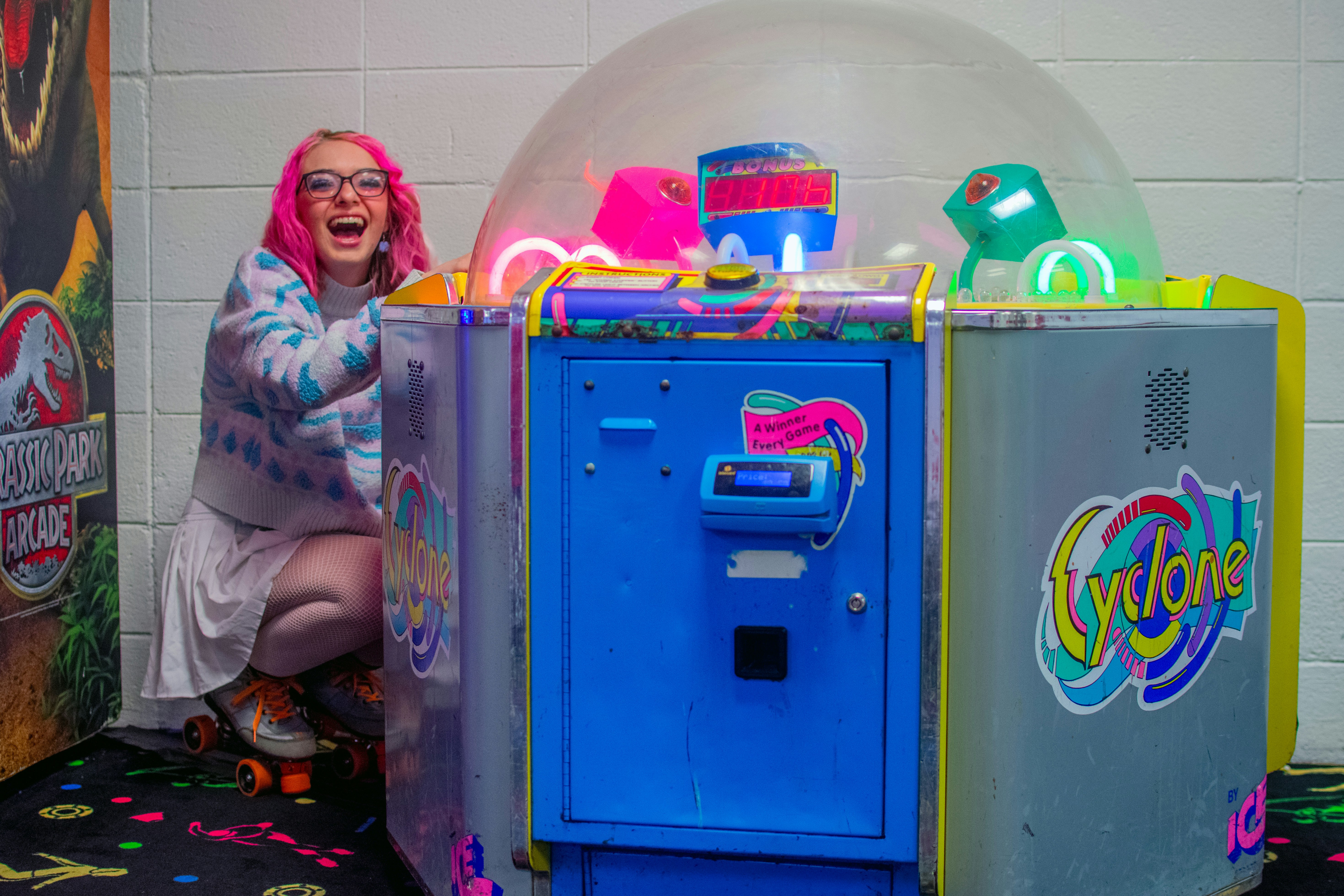 A woman with pink hair sitting in front of a machine