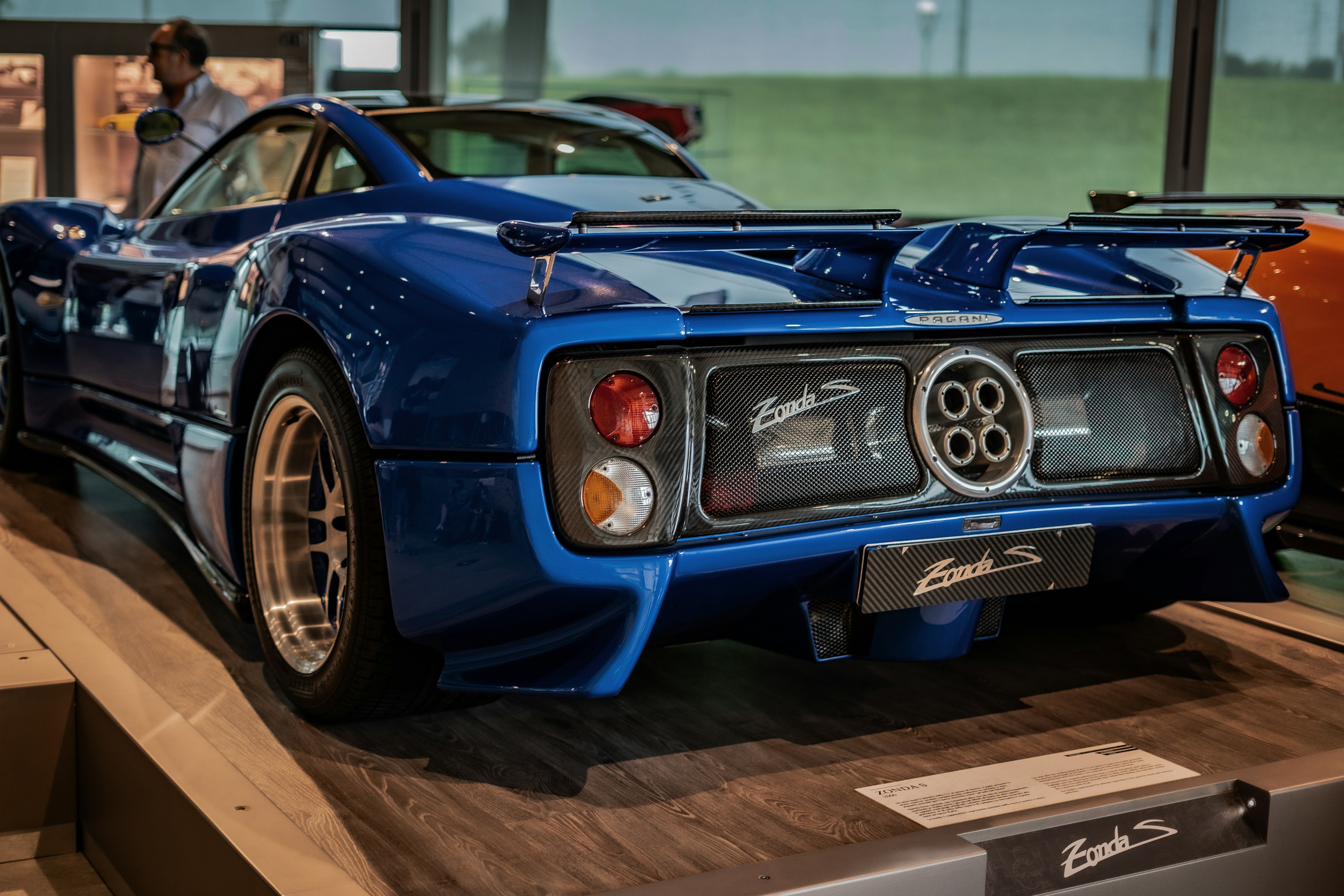 A blue sports car is on display in a museum