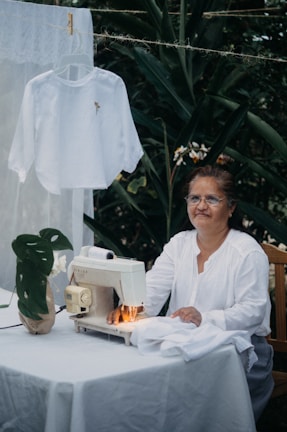 A woman sitting at a table with a sewing machine