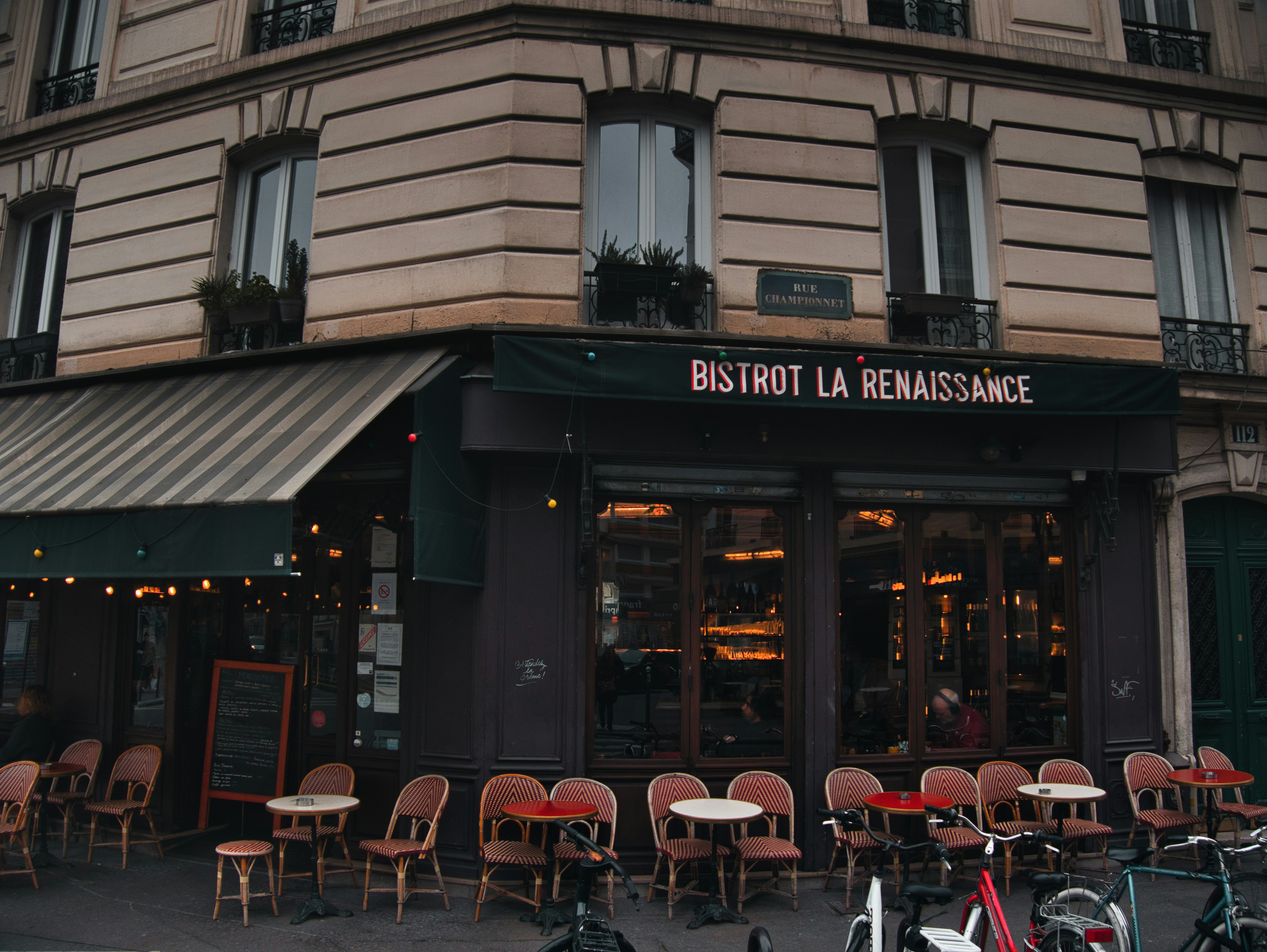 a restaurant with tables and chairs outside of it