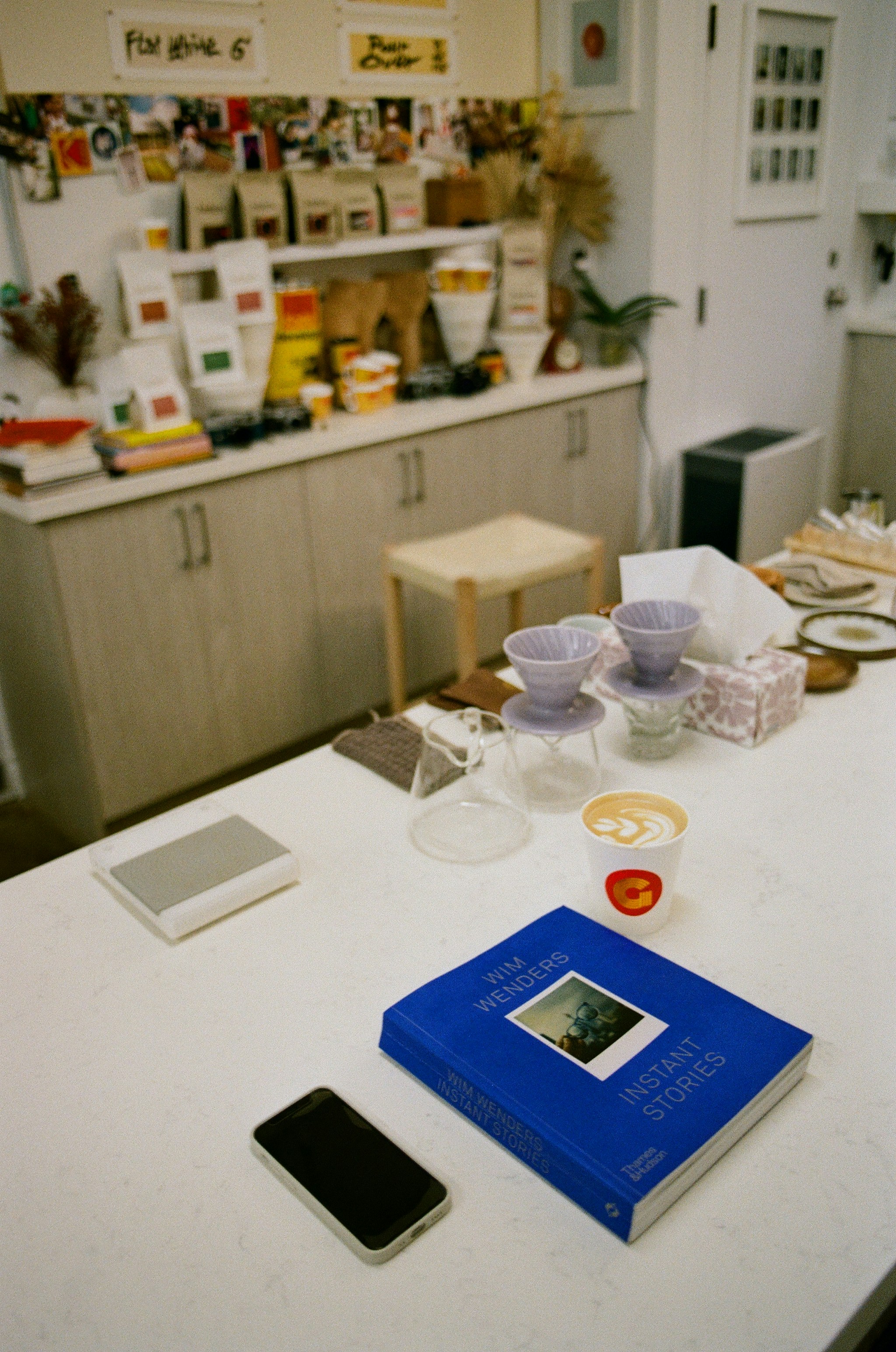 A kitchen counter with a blue book and a cell phone on it