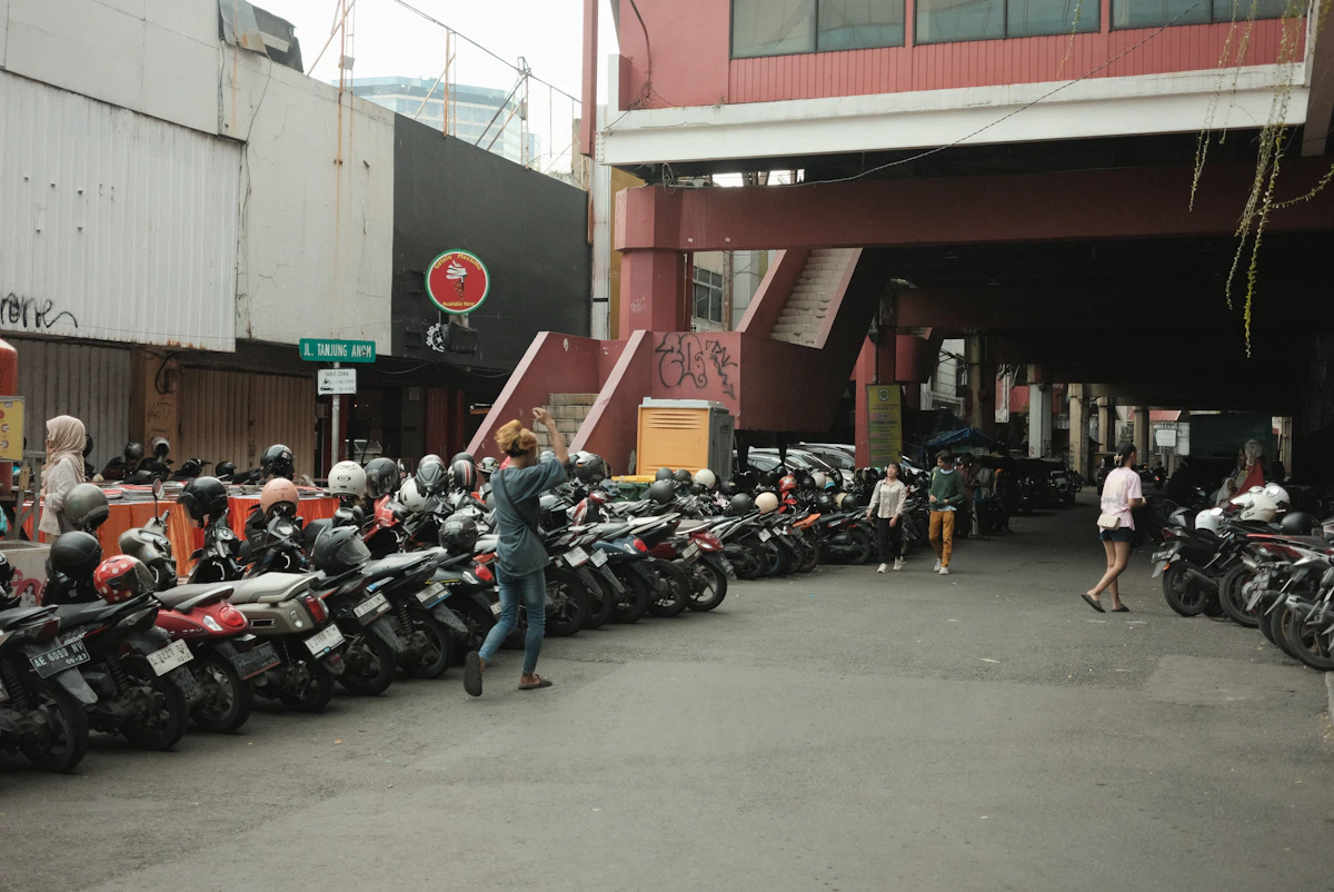 Deretan sepeda motor terparkir berdampingan di area parkir.