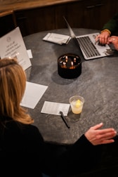 A couple of people sitting at a table with laptops