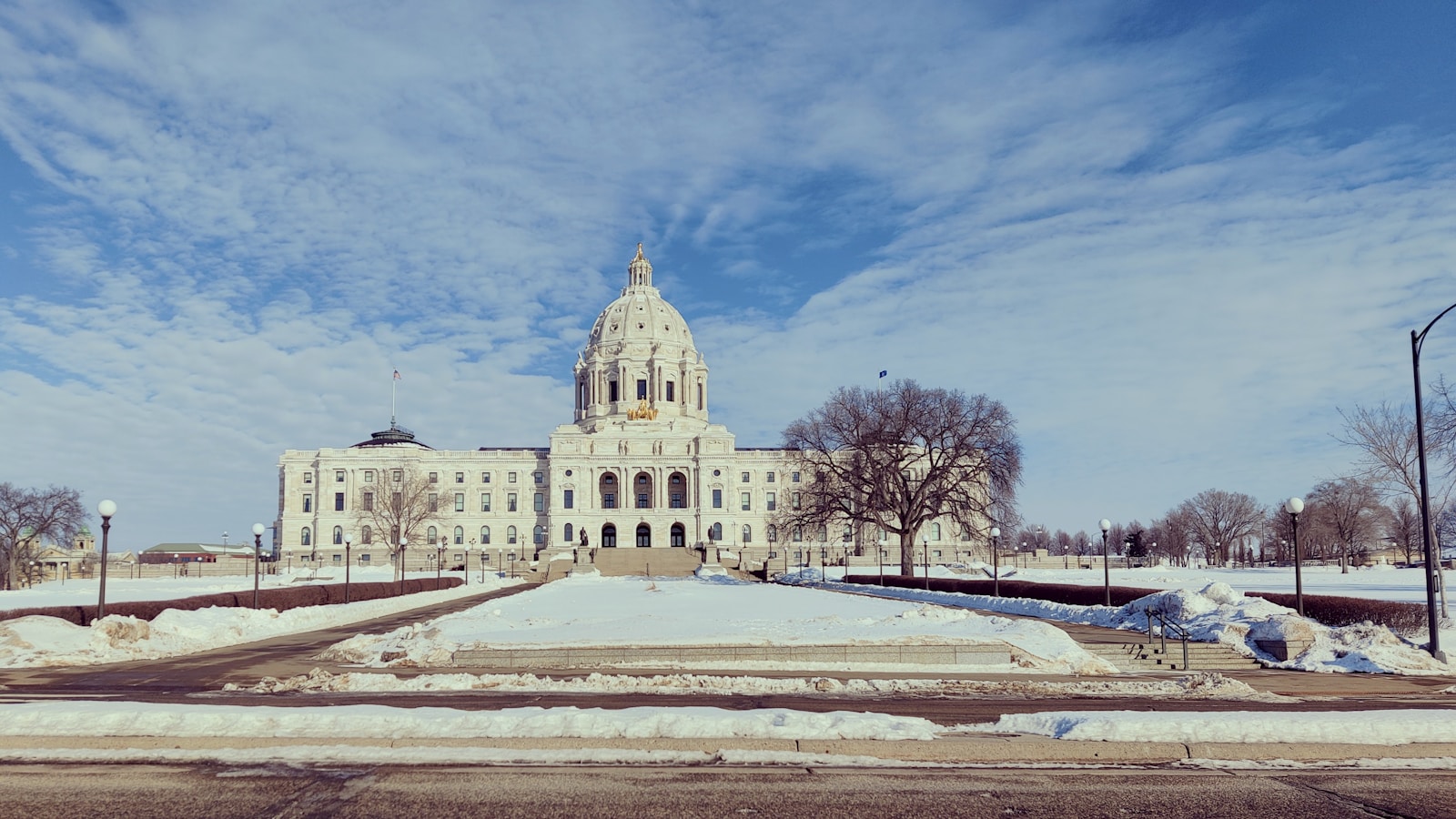 Minnesota State Capitol under a blue sky with snow covering the lawn