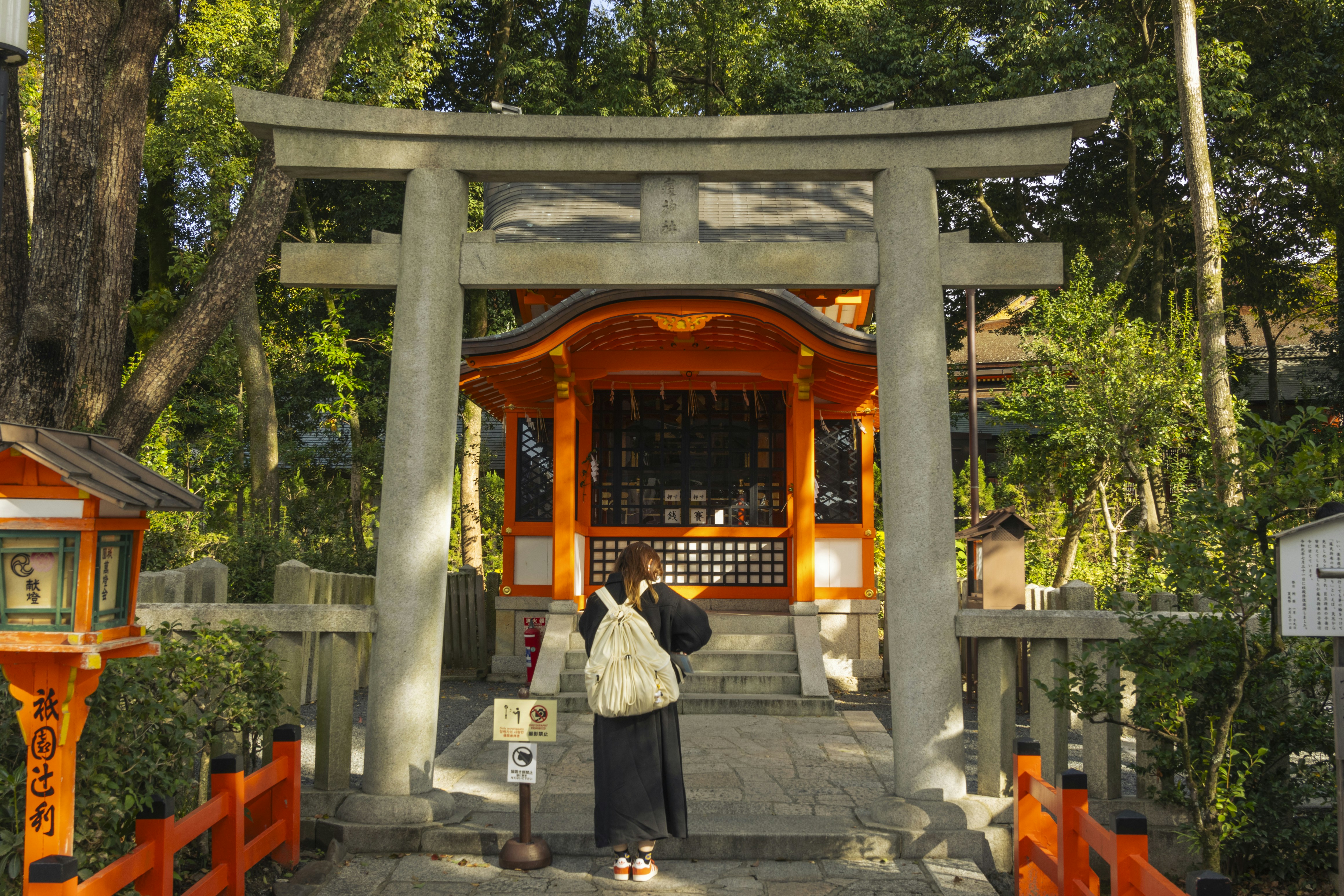 Person bowing before entering a Japanese torii gate