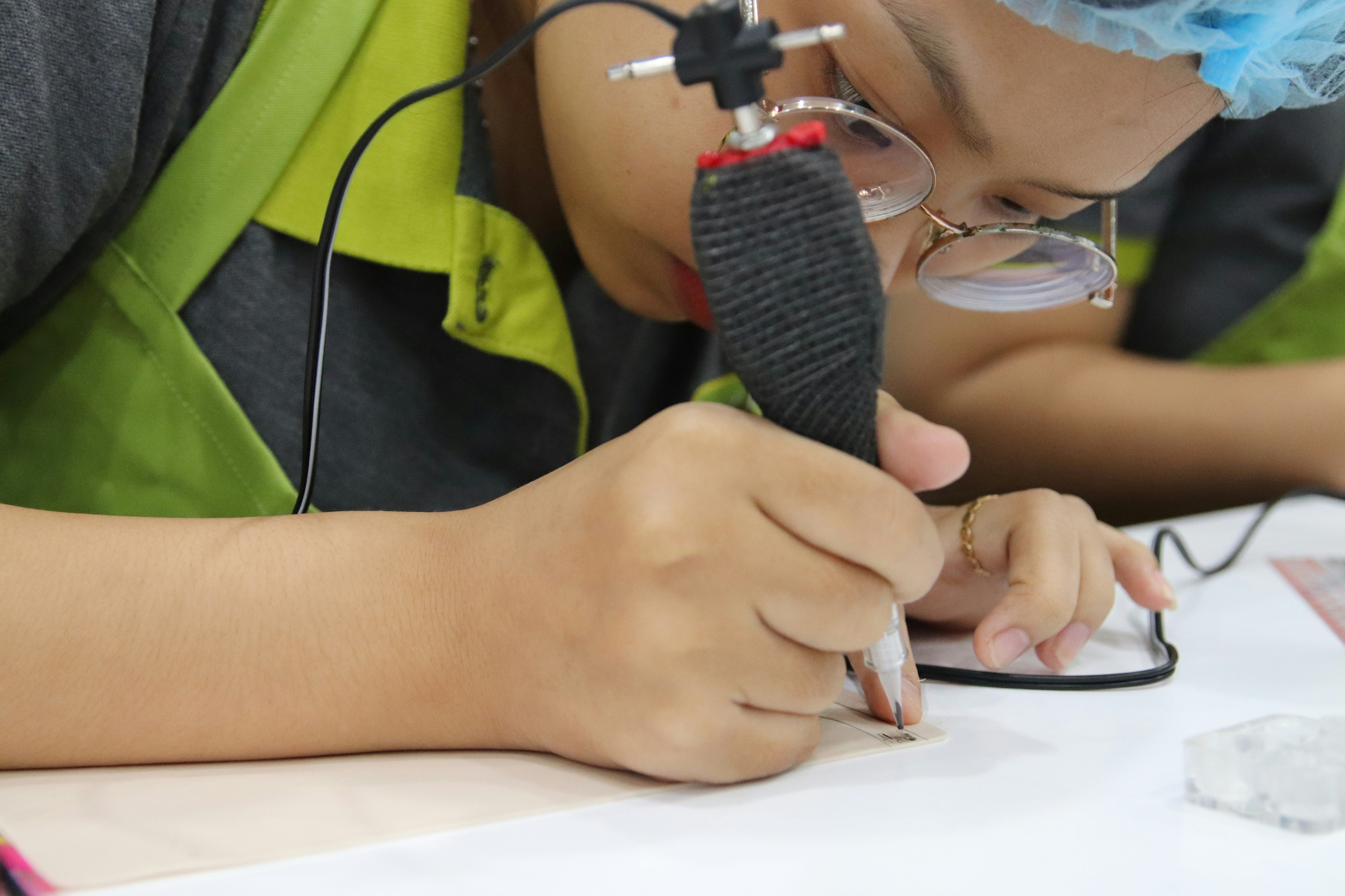 A couple of kids sitting at a table working on a project