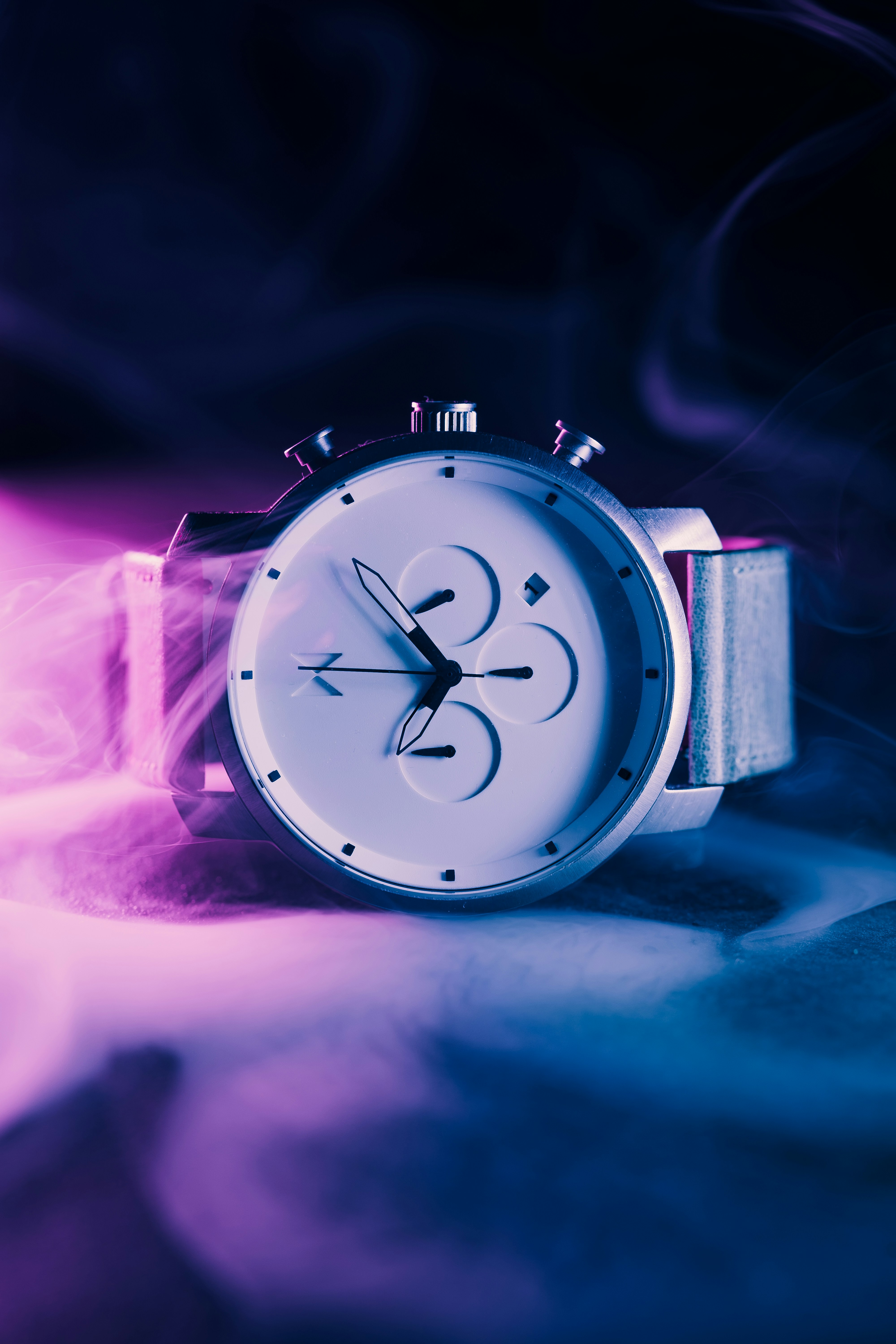 A watch sitting on top of a table covered in smoke