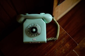 An old fashioned phone sitting on a wooden table
