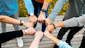 A group of people putting their hands together