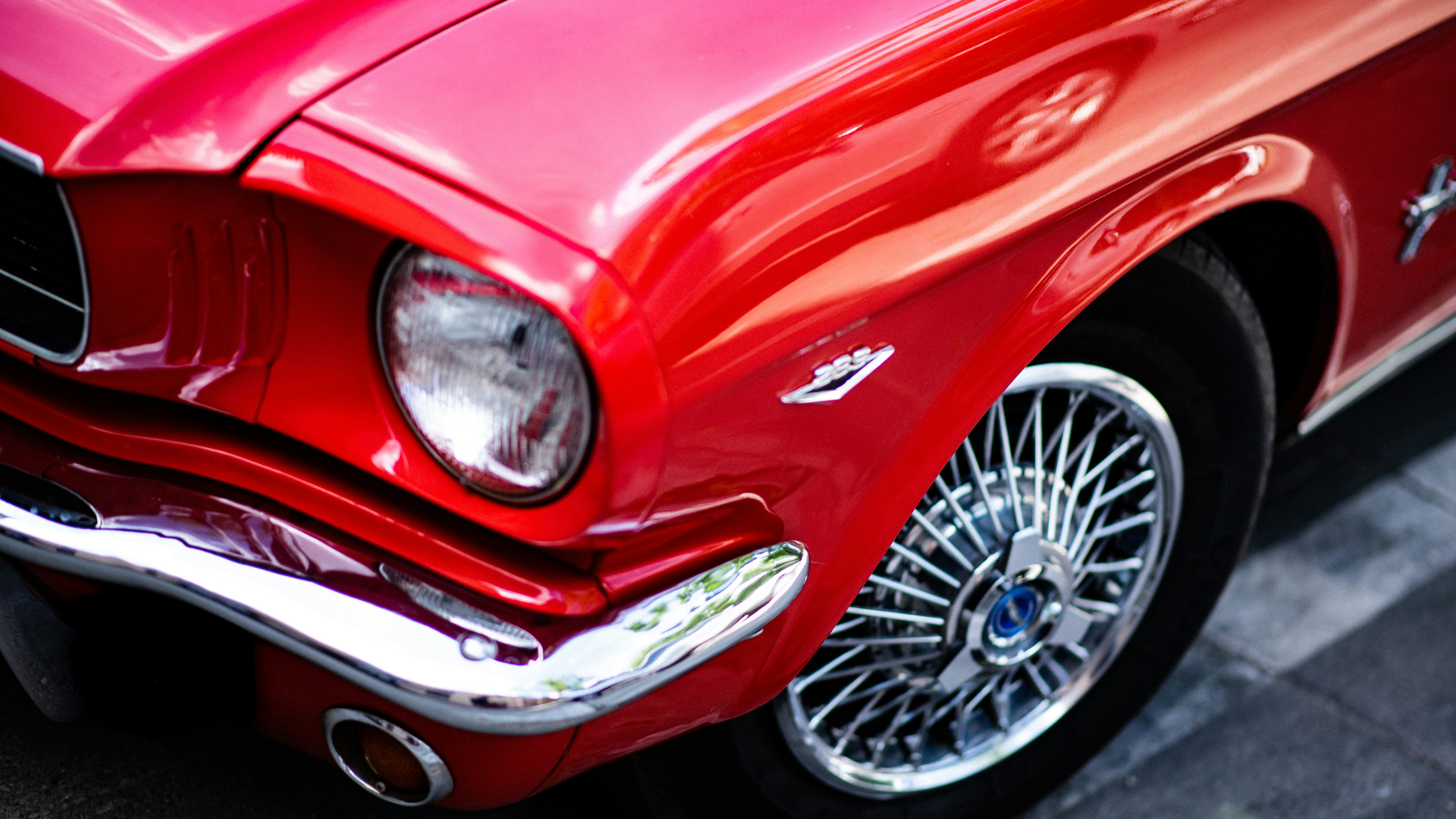 A close up of the front of a red mustang