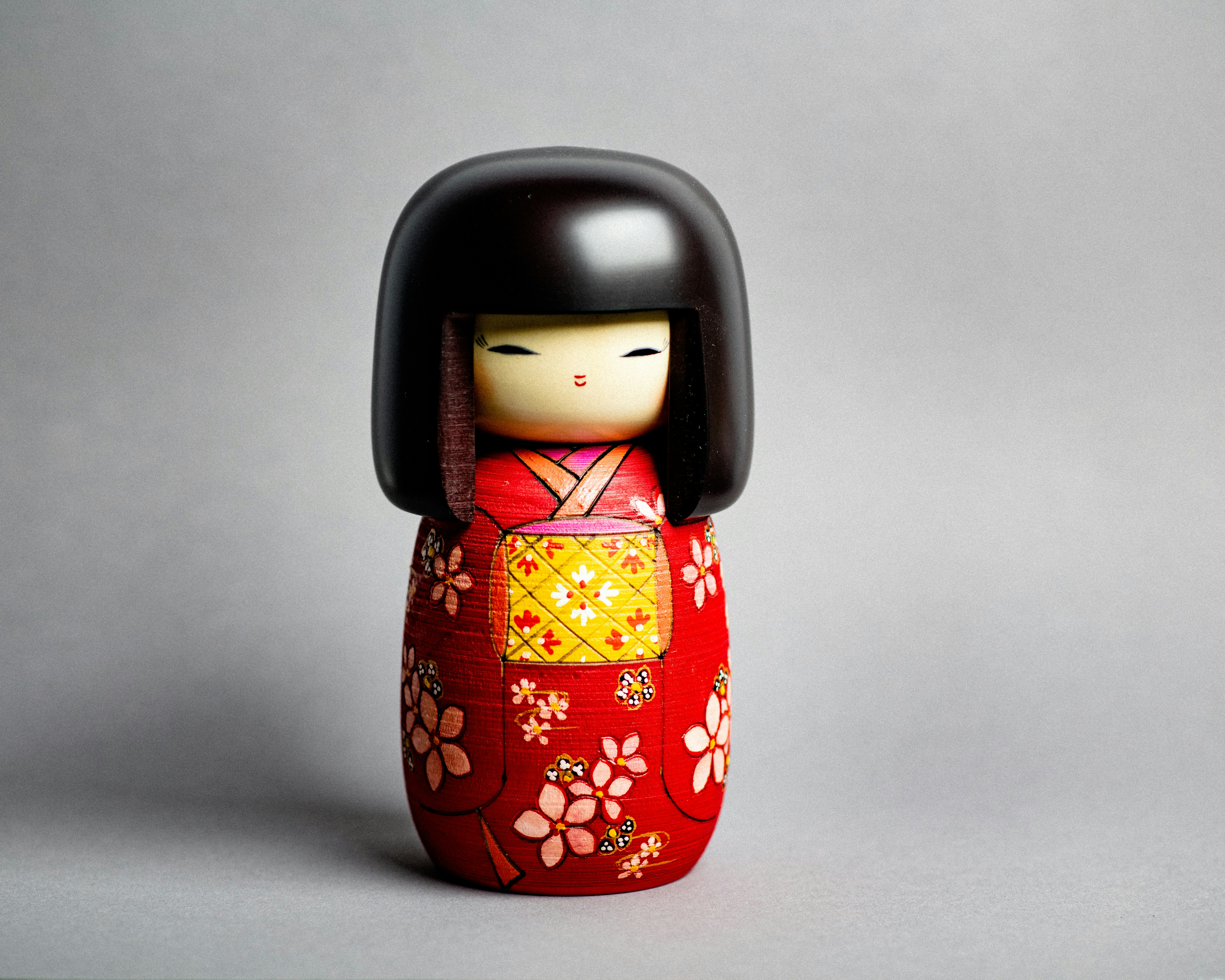 A small doll with a red and yellow kimono
