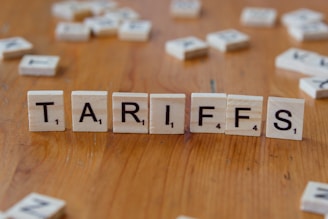 A wooden block spelling tarifs on a table