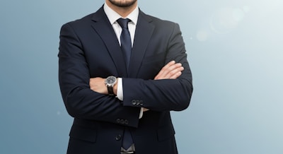 A man in a suit and tie standing with his arms crossed