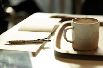 A cup of coffee sitting on top of a white plate
