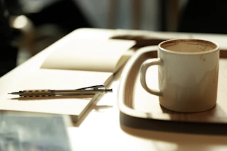 A cup of coffee sitting on top of a white plate